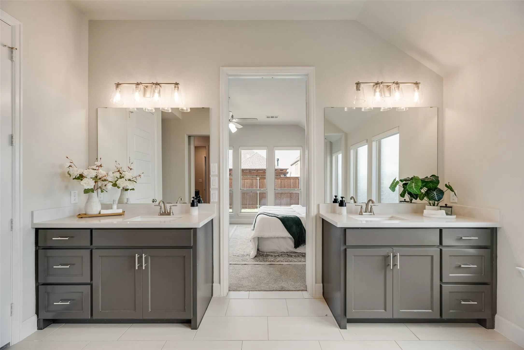 Dual vanity bathroom featuring gray cabinetry, integrated sinks, white countertops, and brushed nickel fixtures