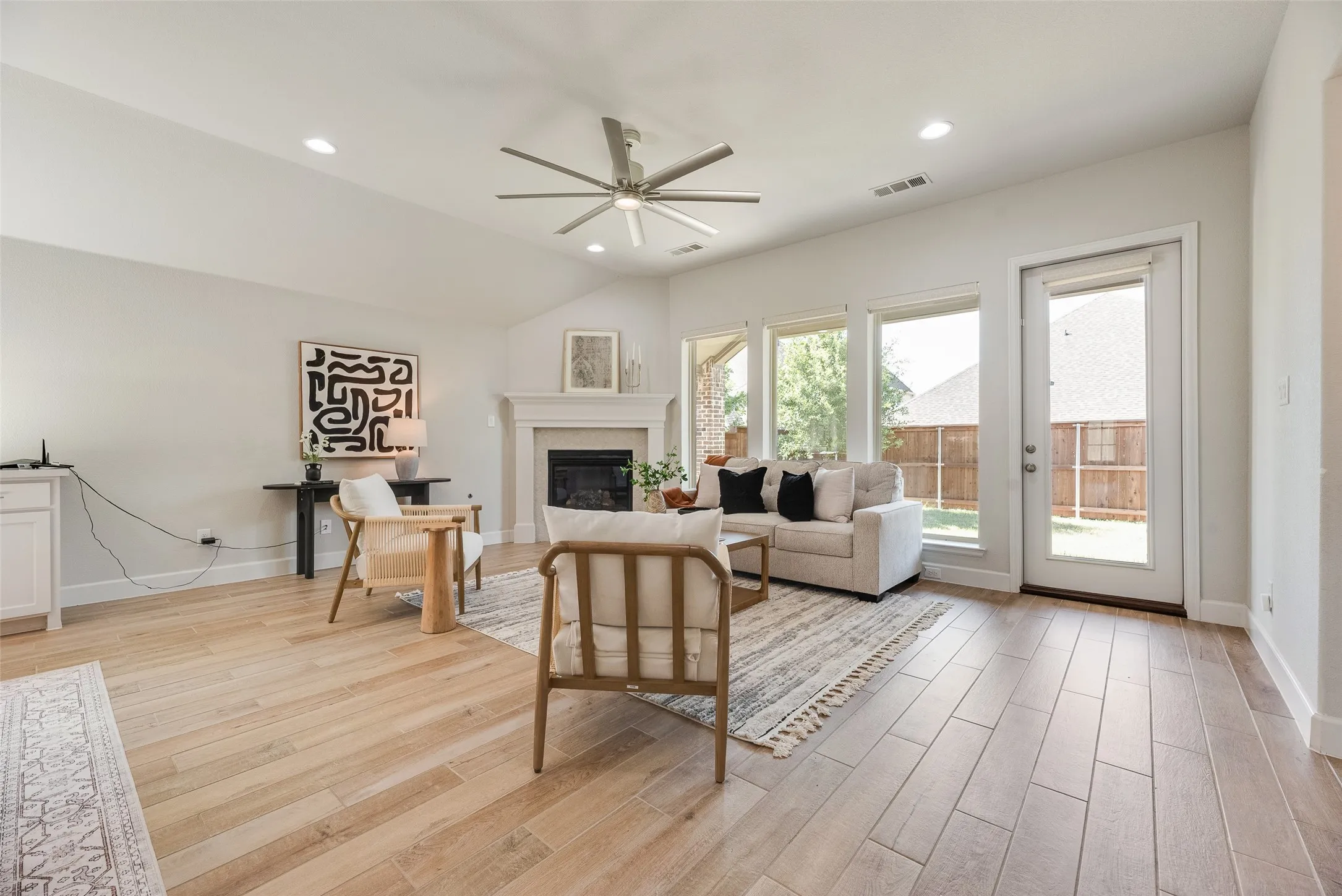 Spacious living area featuring a vaulted ceiling with a ceiling fan, recessed lighting, and light wood-finish flooring