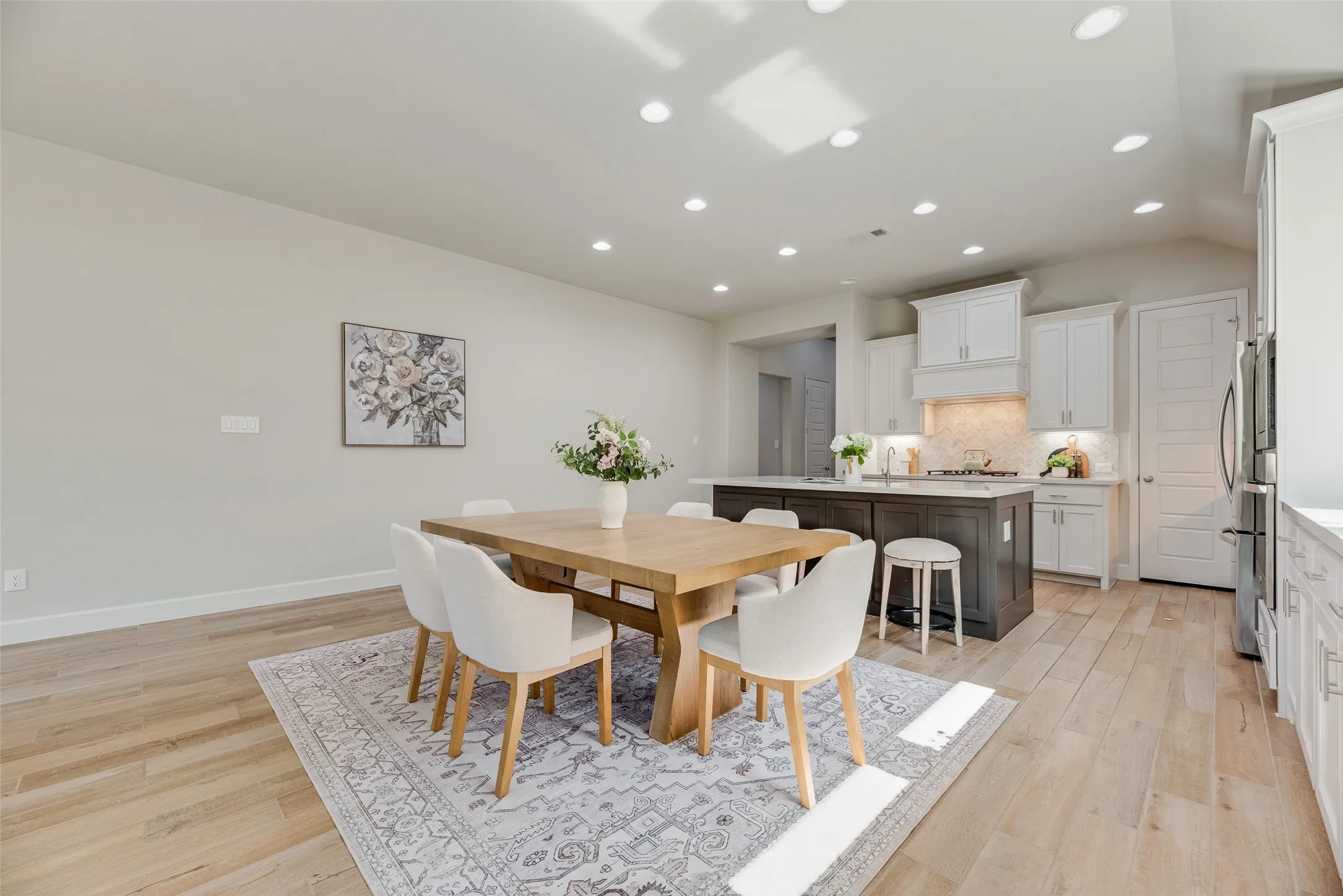 Open-concept living space featuring wood-finish flooring, recessed lighting, and a neutral color palette