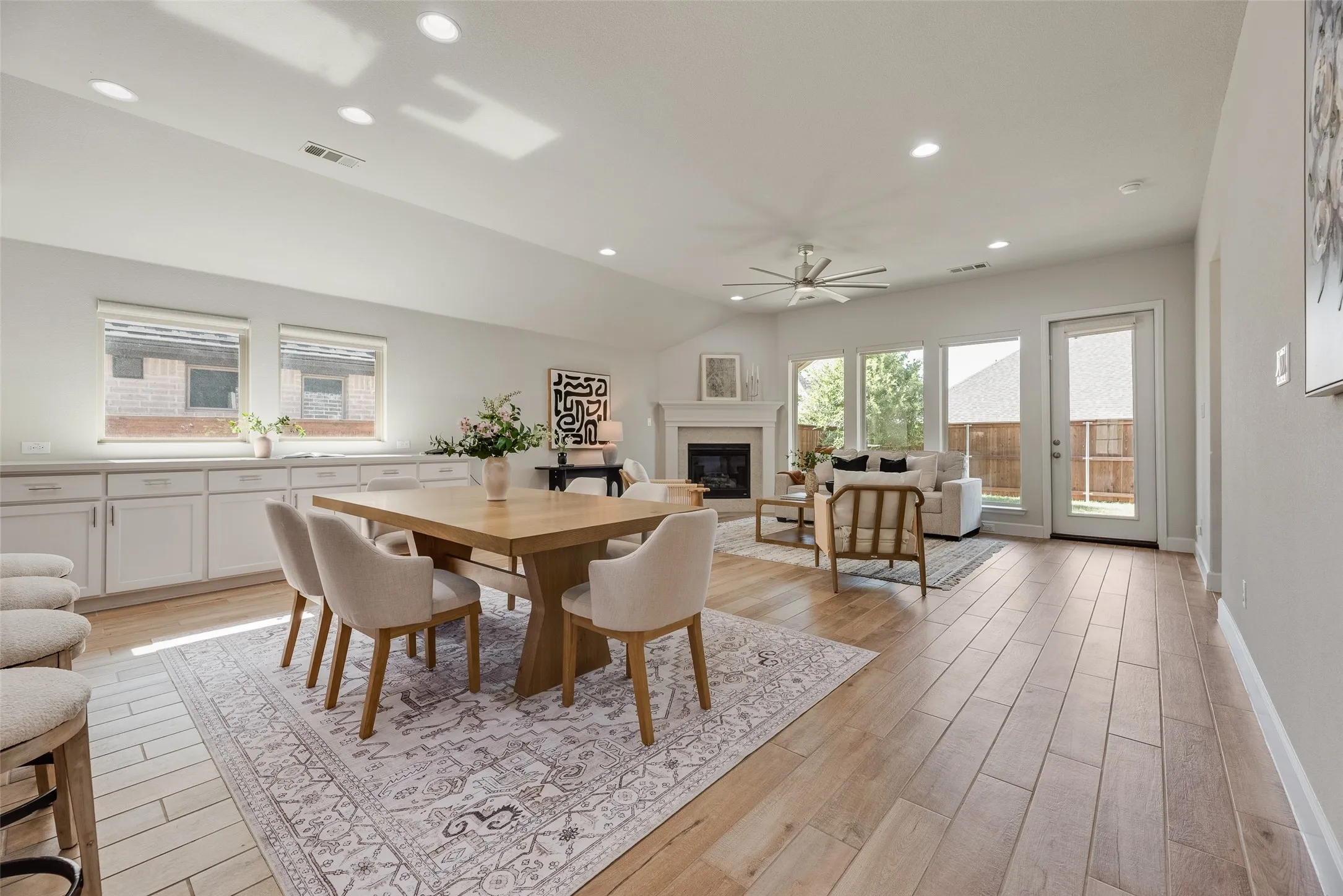 Expansive open-concept living area featuring wood-finish flooring, recessed lighting, and a vaulted ceiling