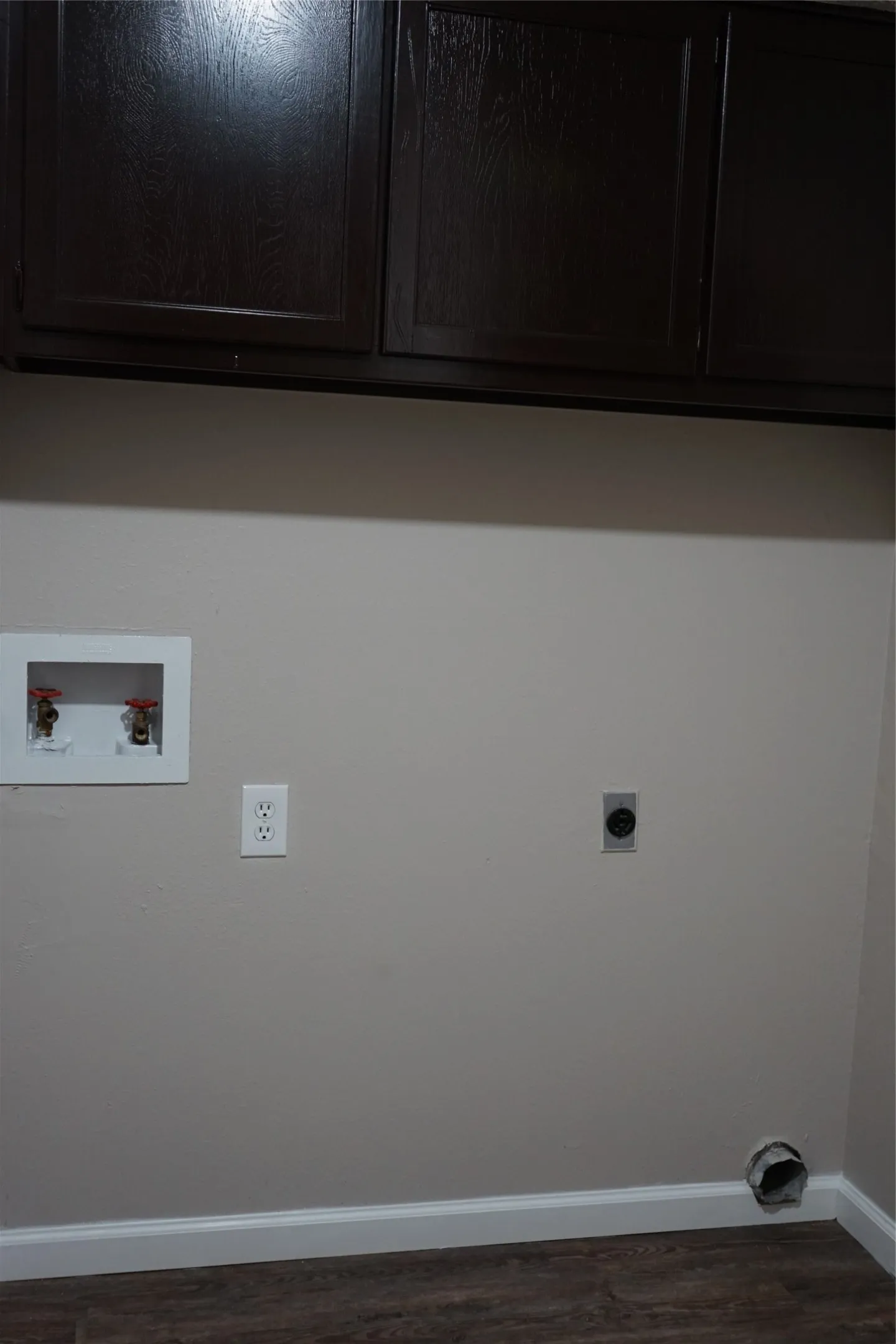 Full size washer dryer laundry area with cabinets