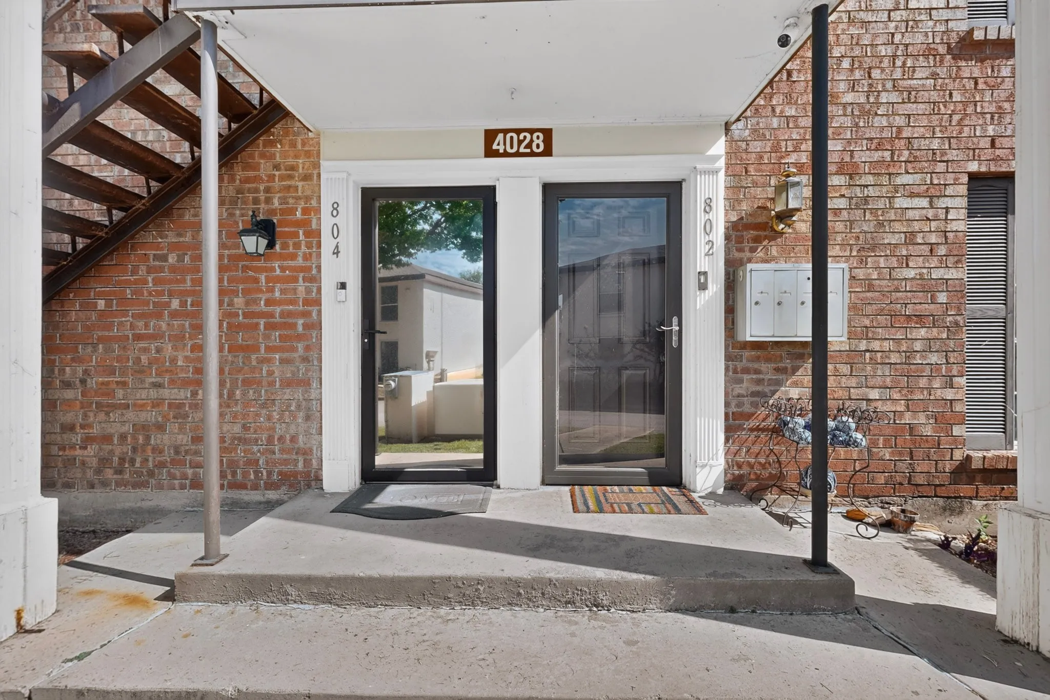Brick exterior featuring two entry doors with security screens