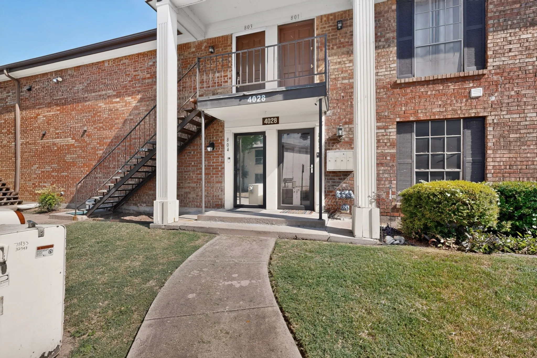 Brick exterior with black window shutters and a metal exterior staircase
