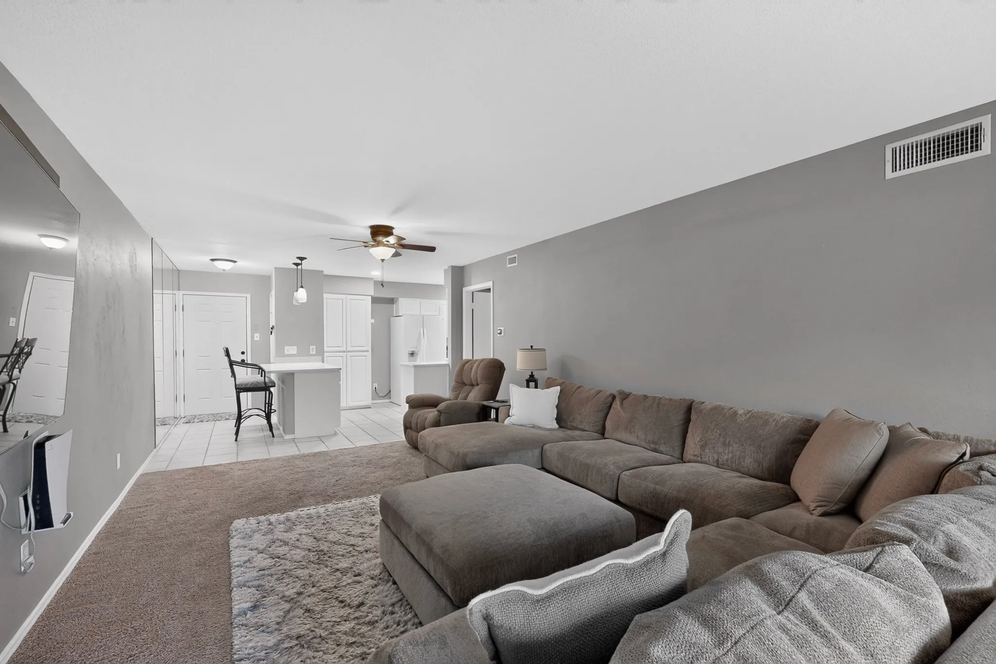Open concept living space featuring neutral gray walls and carpeting