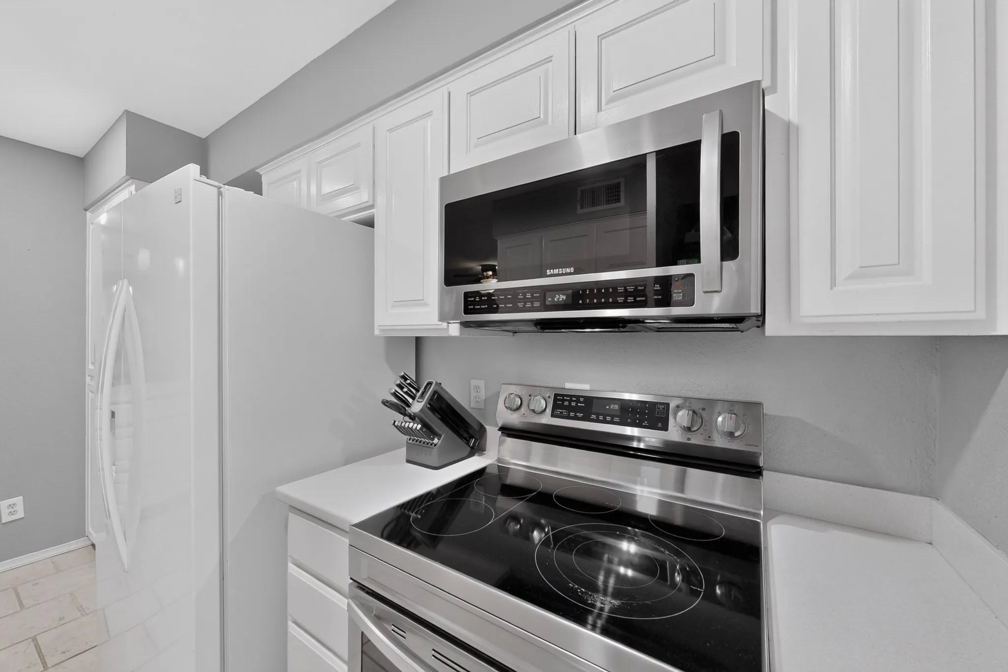 Kitchen featuring white cabinetry and light countertops