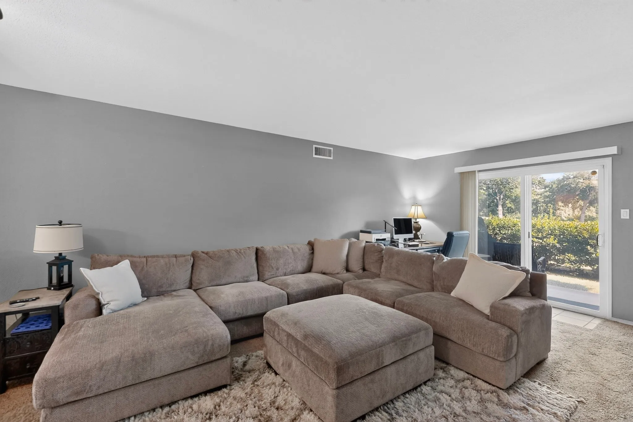 Living area with light gray walls, white baseboards, and a sliding glass door providing exterior access