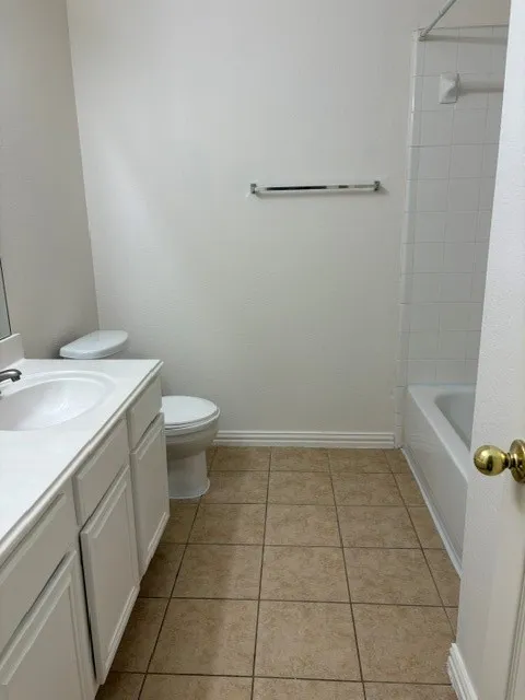 Bathroom with neutral wall paint and light-toned tile flooring