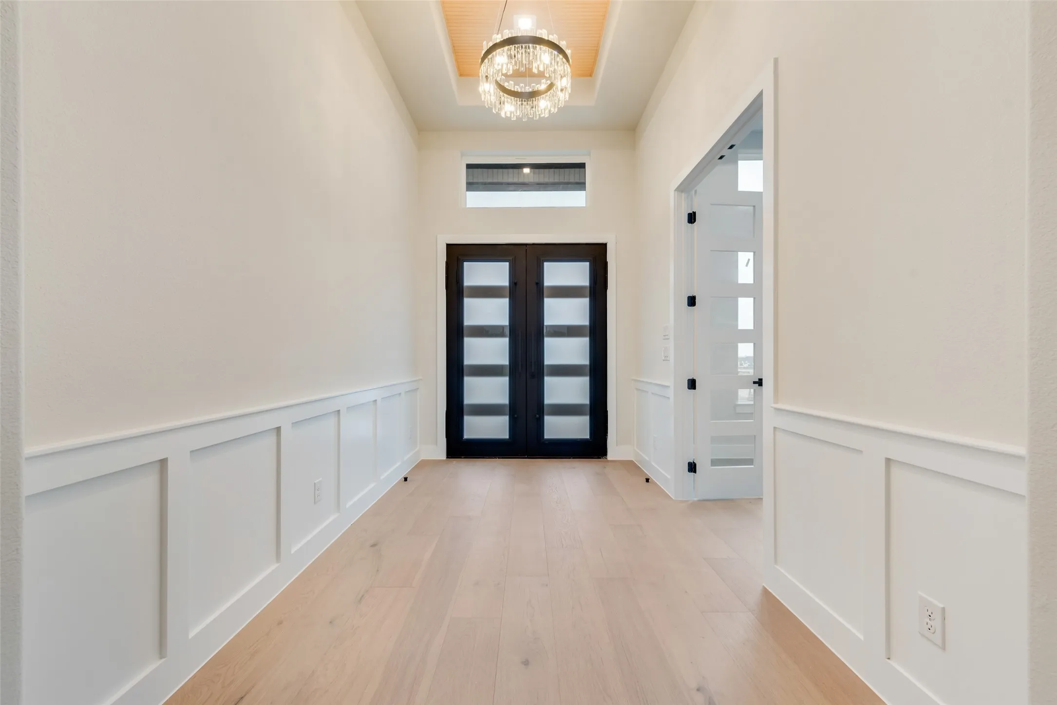 Grand entry hall with light wood-finish flooring