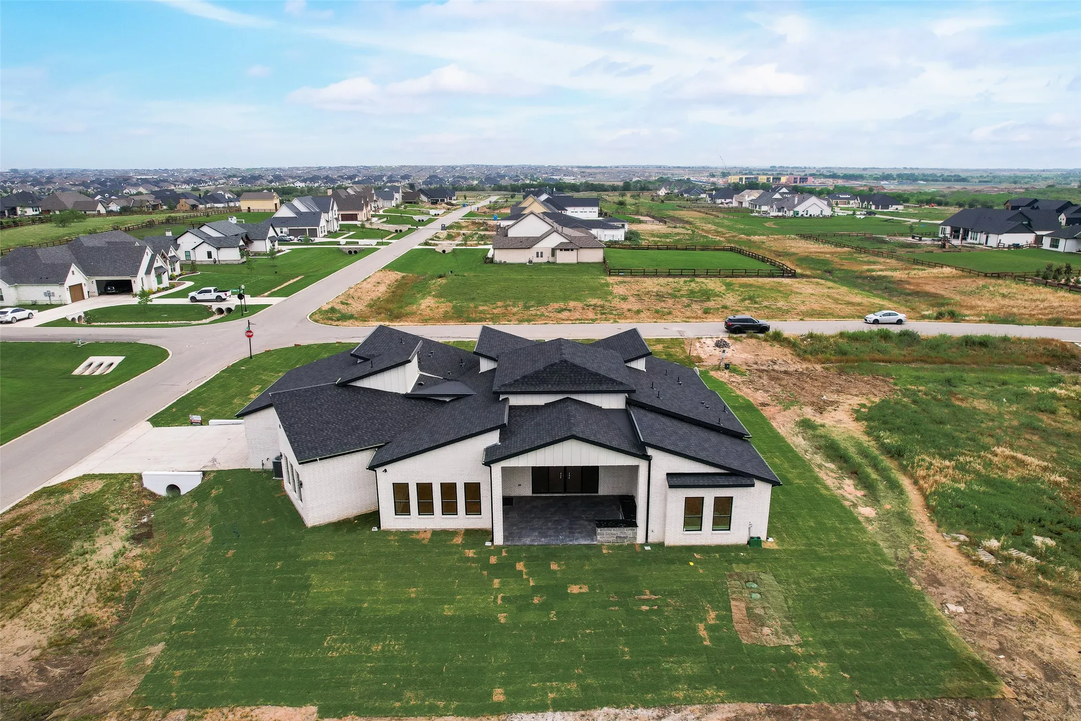 Contemporary-style residence featuring a distinctive multi-gabled black roof and white exterior
