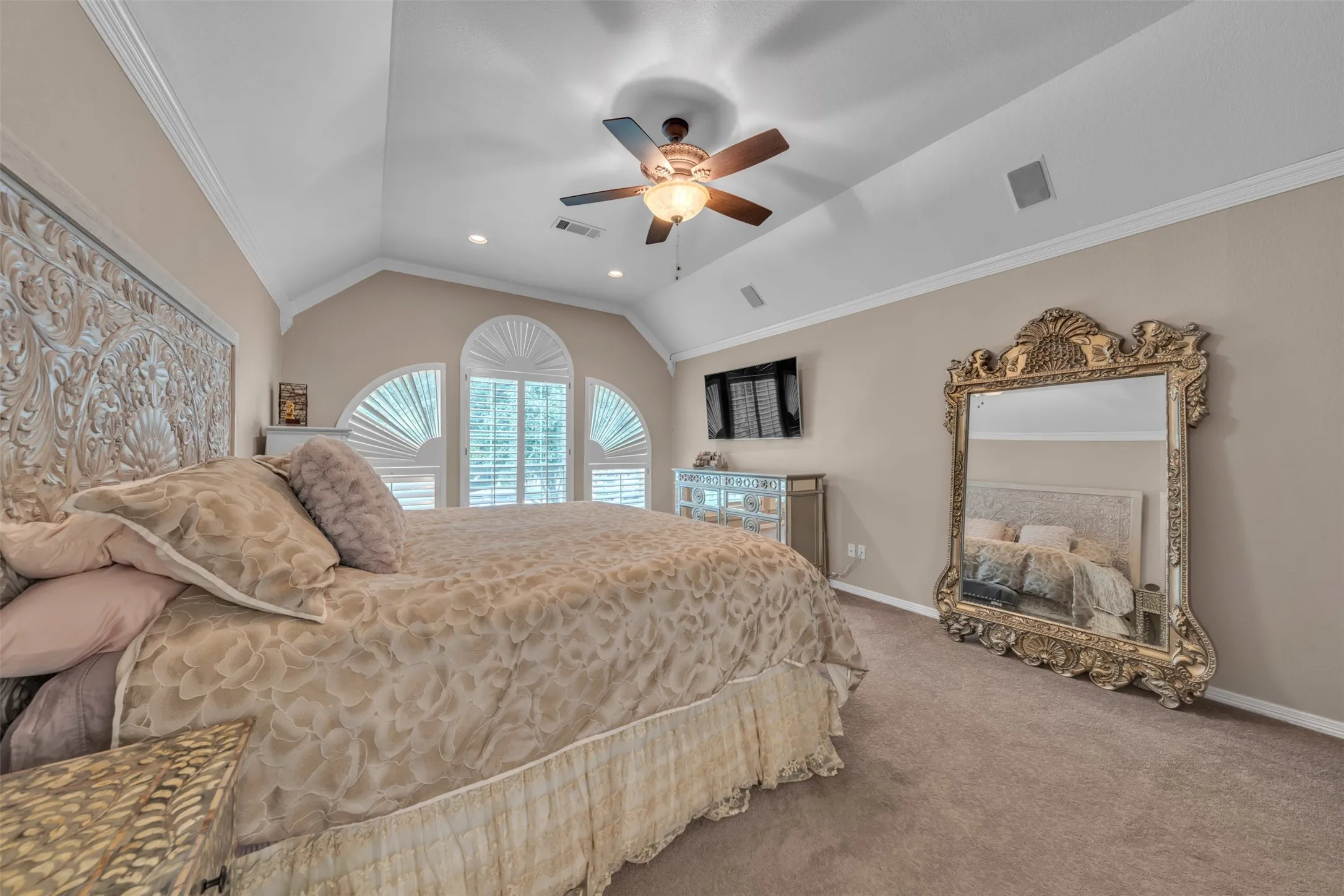 Vaulted ceiling with crown molding, recessed lighting, and a ceiling fan