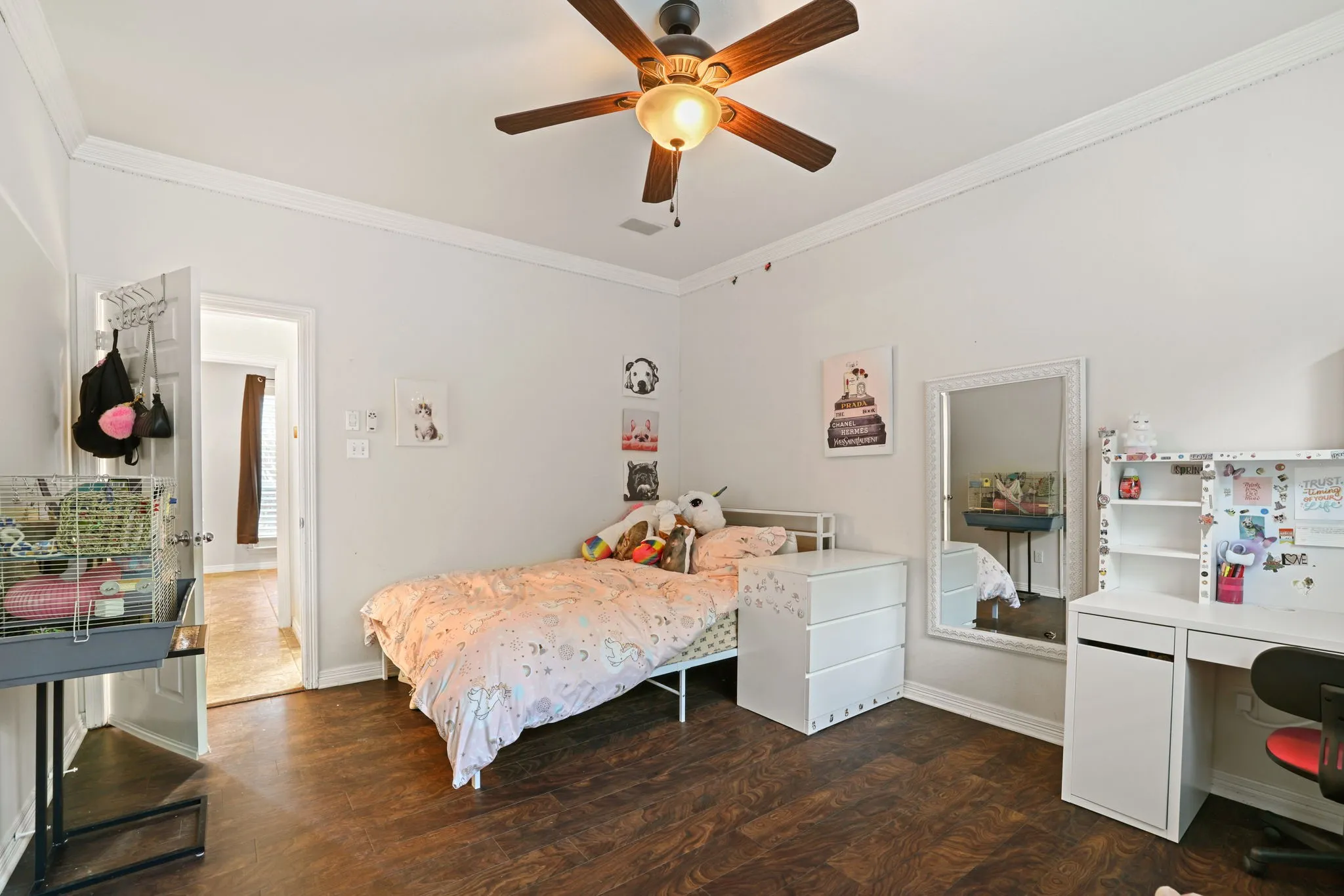 Spacious room featuring wood-finish flooring, white walls, and a ceiling fan with integrated lighting