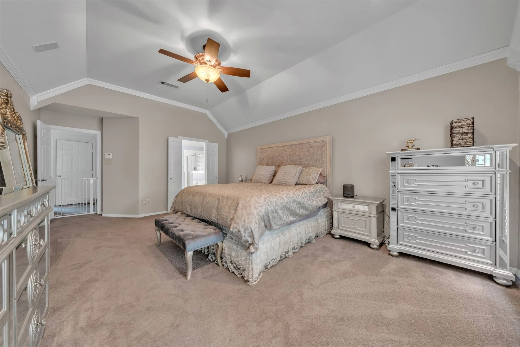 Vaulted ceiling, ceiling fan with light fixture, neutral wall color, carpet flooring, and white trim