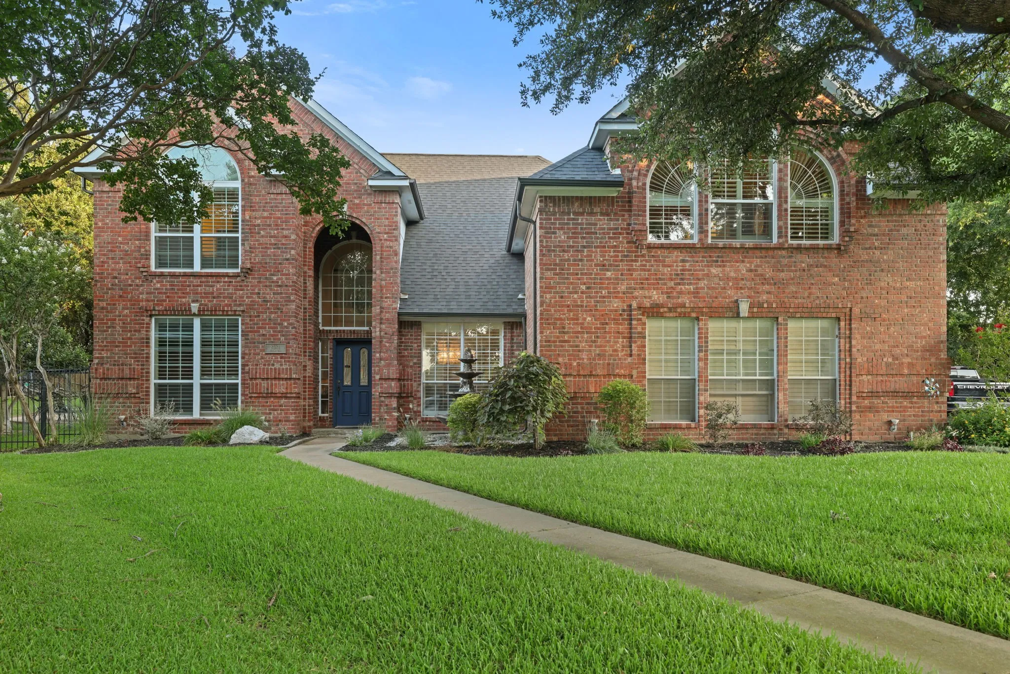 Traditional brick facade with a prominent gabled roofline and a dark blue entry door