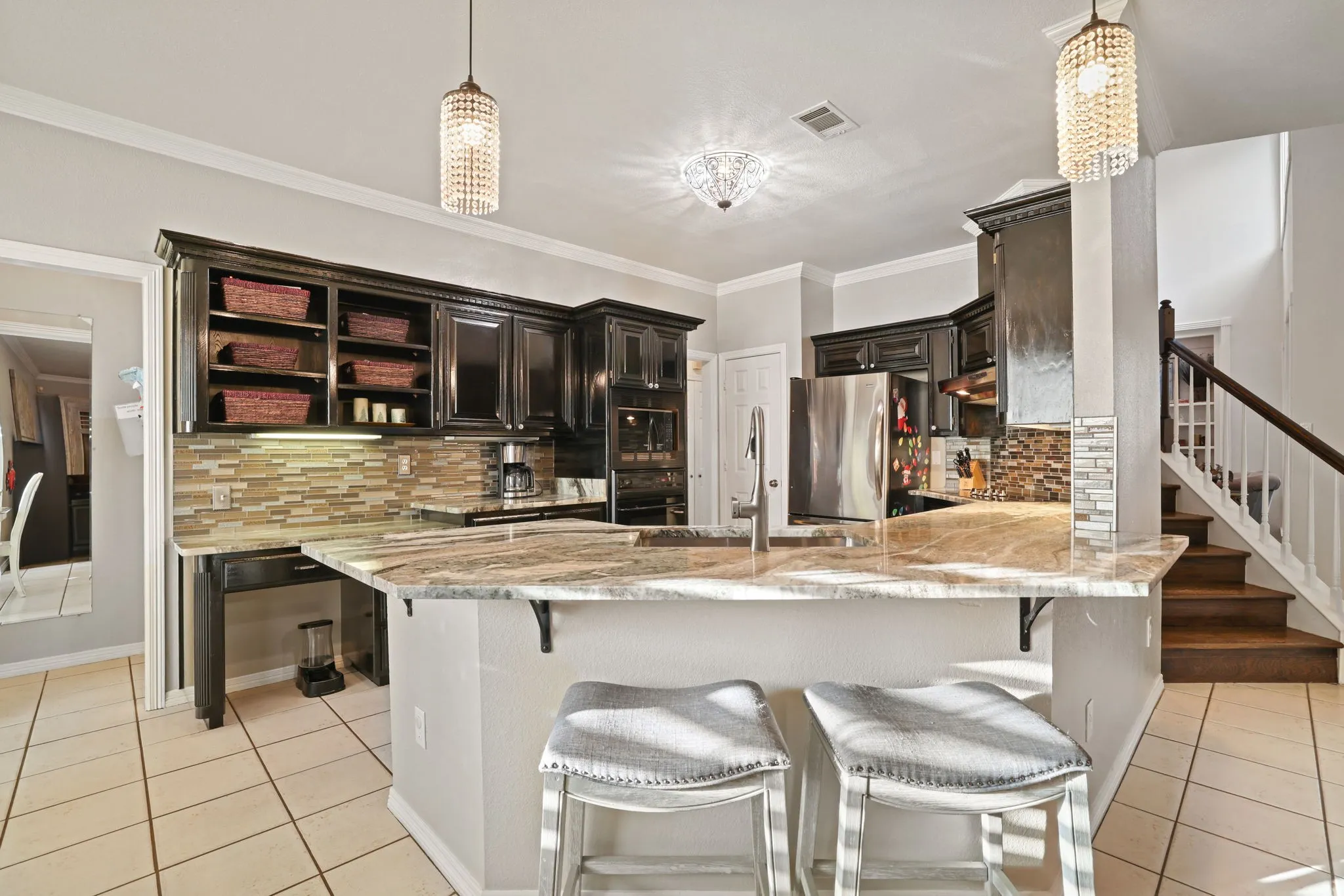 Kitchen featuring dark wood cabinetry, granite countertops, and a mosaic tile backsplash
