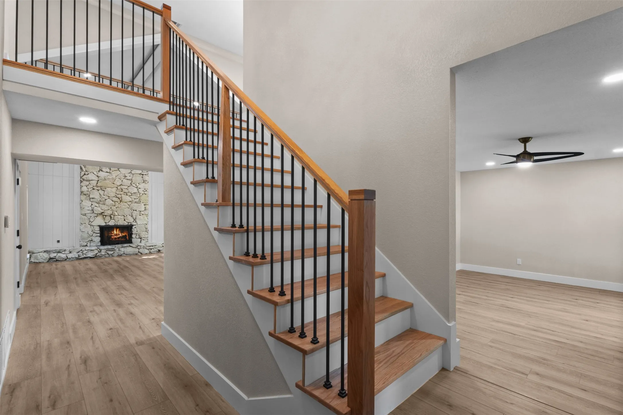 Central staircase featuring wood treads, painted risers, and black metal balusters