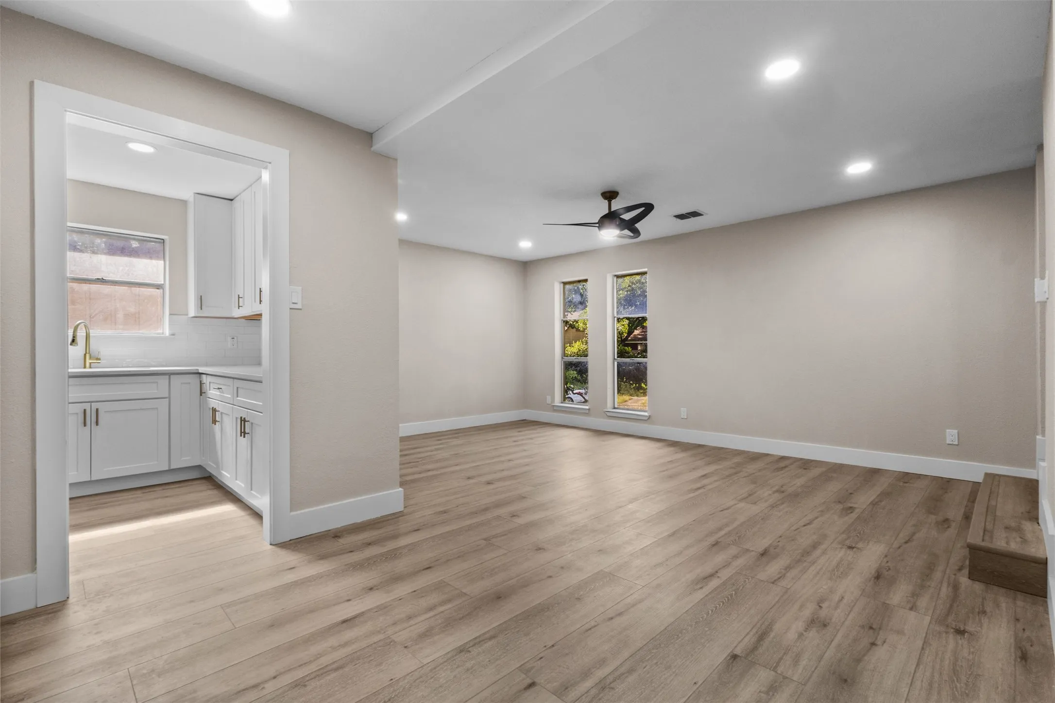 Open-concept living area featuring wood-finish flooring, recessed lighting, and a ceiling fan