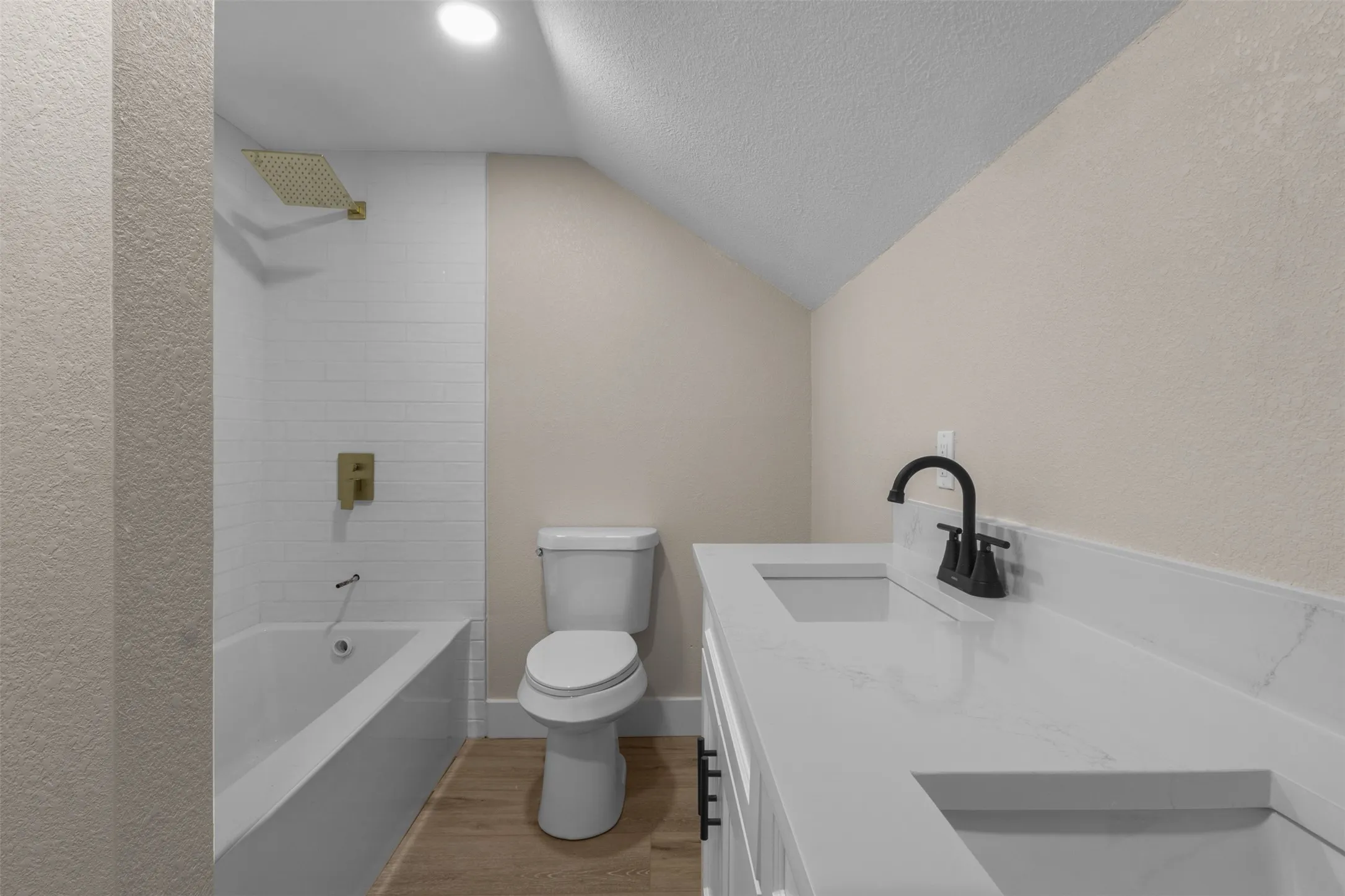 Bathroom featuring a double vanity with stone countertops, integrated sinks, and matte black fixtures
