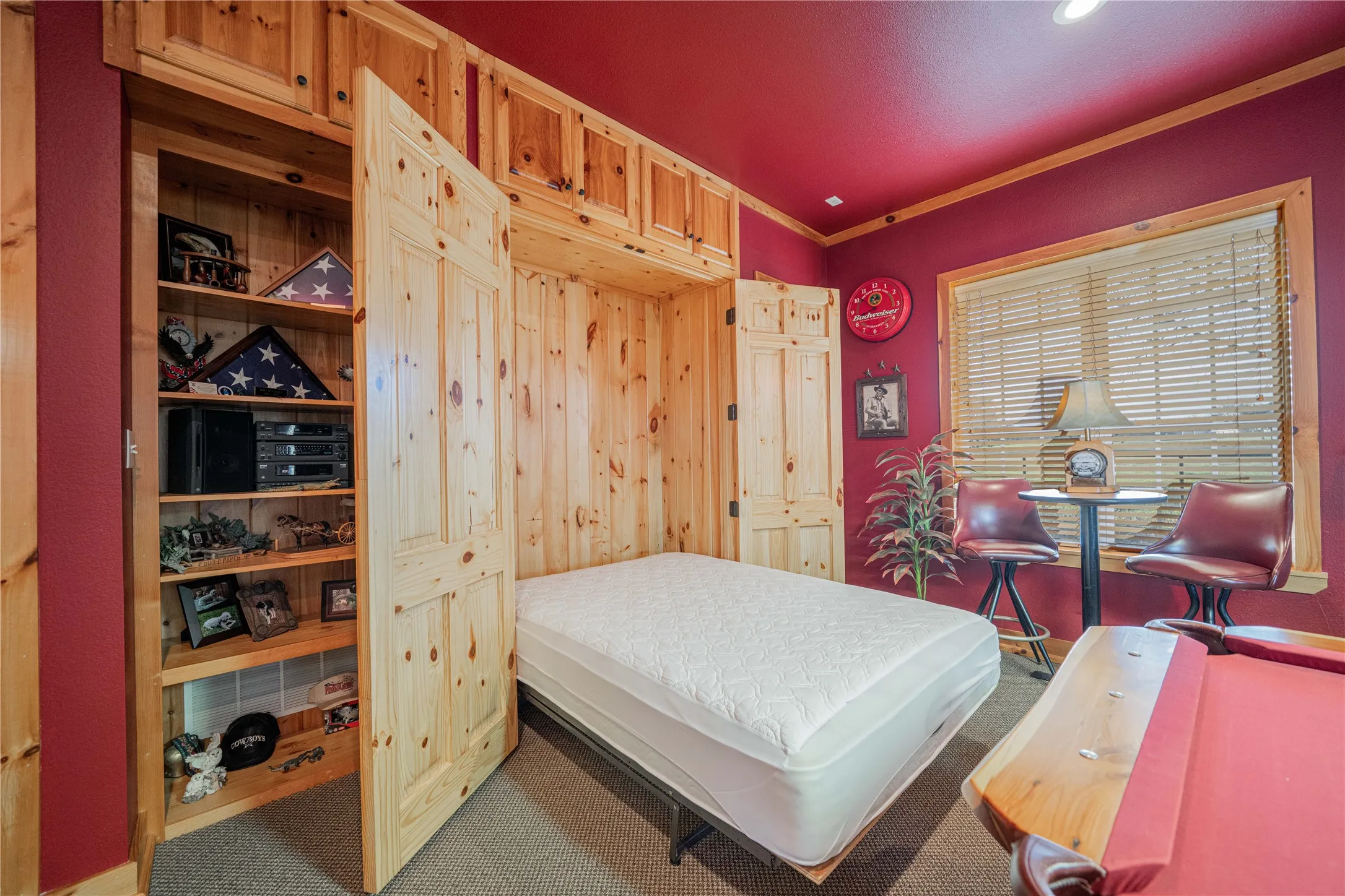 Integrated Murphy bed system with natural wood paneling, complementing a built-in storage unit with adjustable shelving