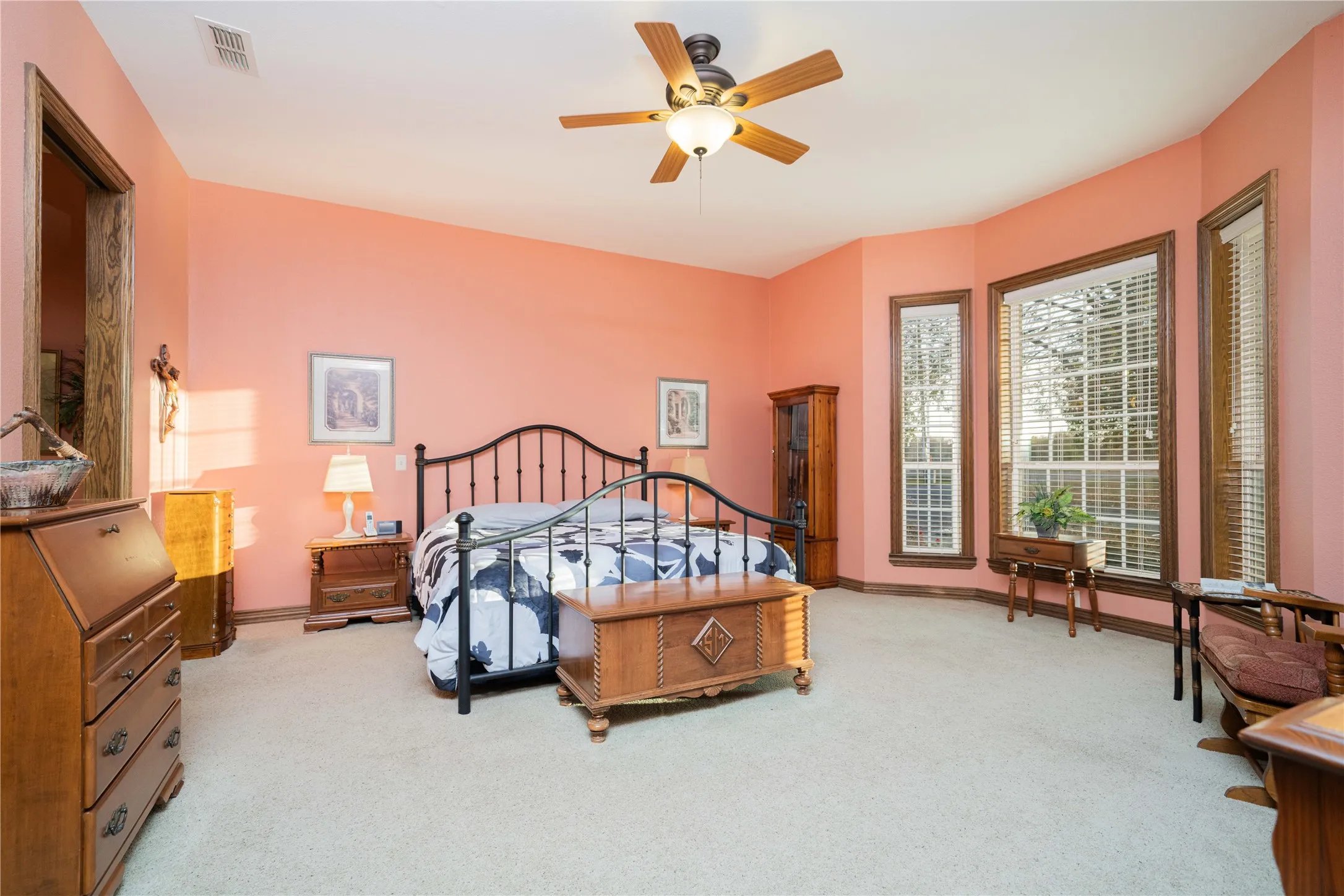 Spacious bedroom featuring light-toned carpeting and a vaulted ceiling