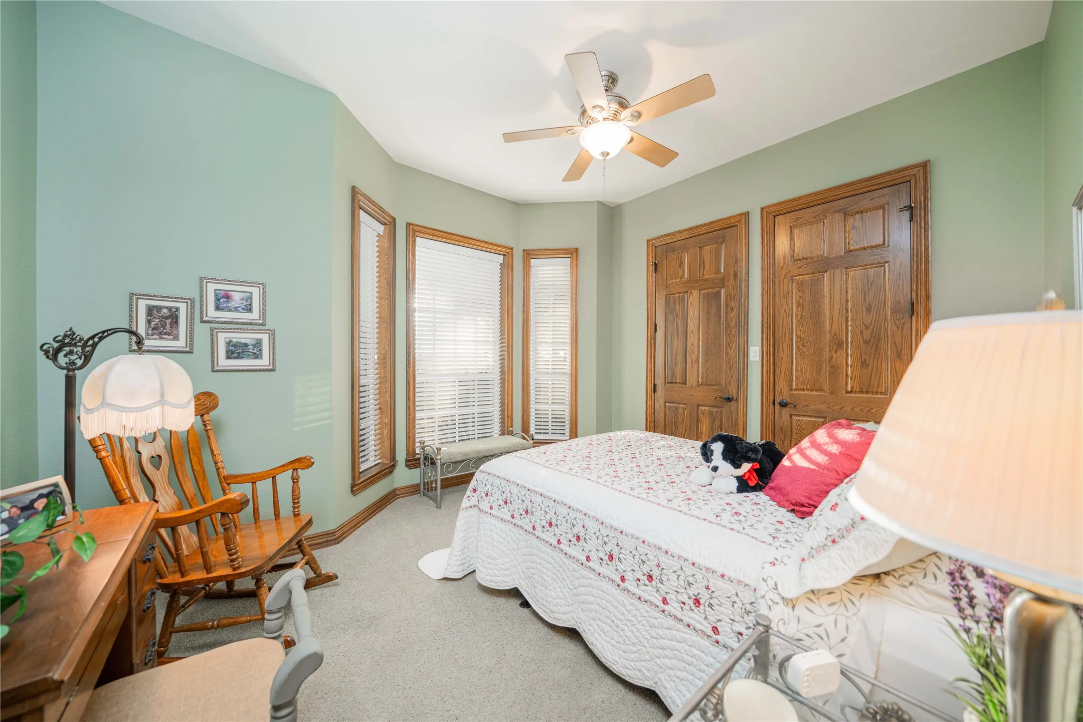 Interior room featuring a ceiling fan, light green walls, and carpeted flooring
