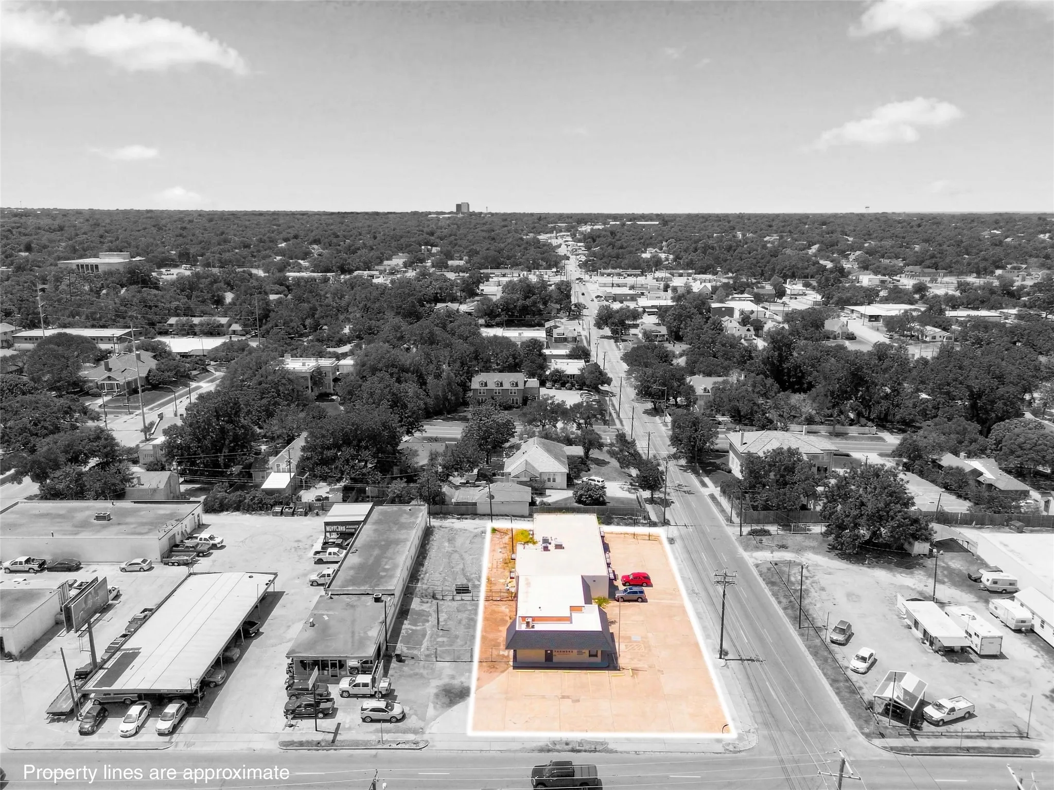 Commercial property featuring a single-story building with a flat roof and a paved parking lot