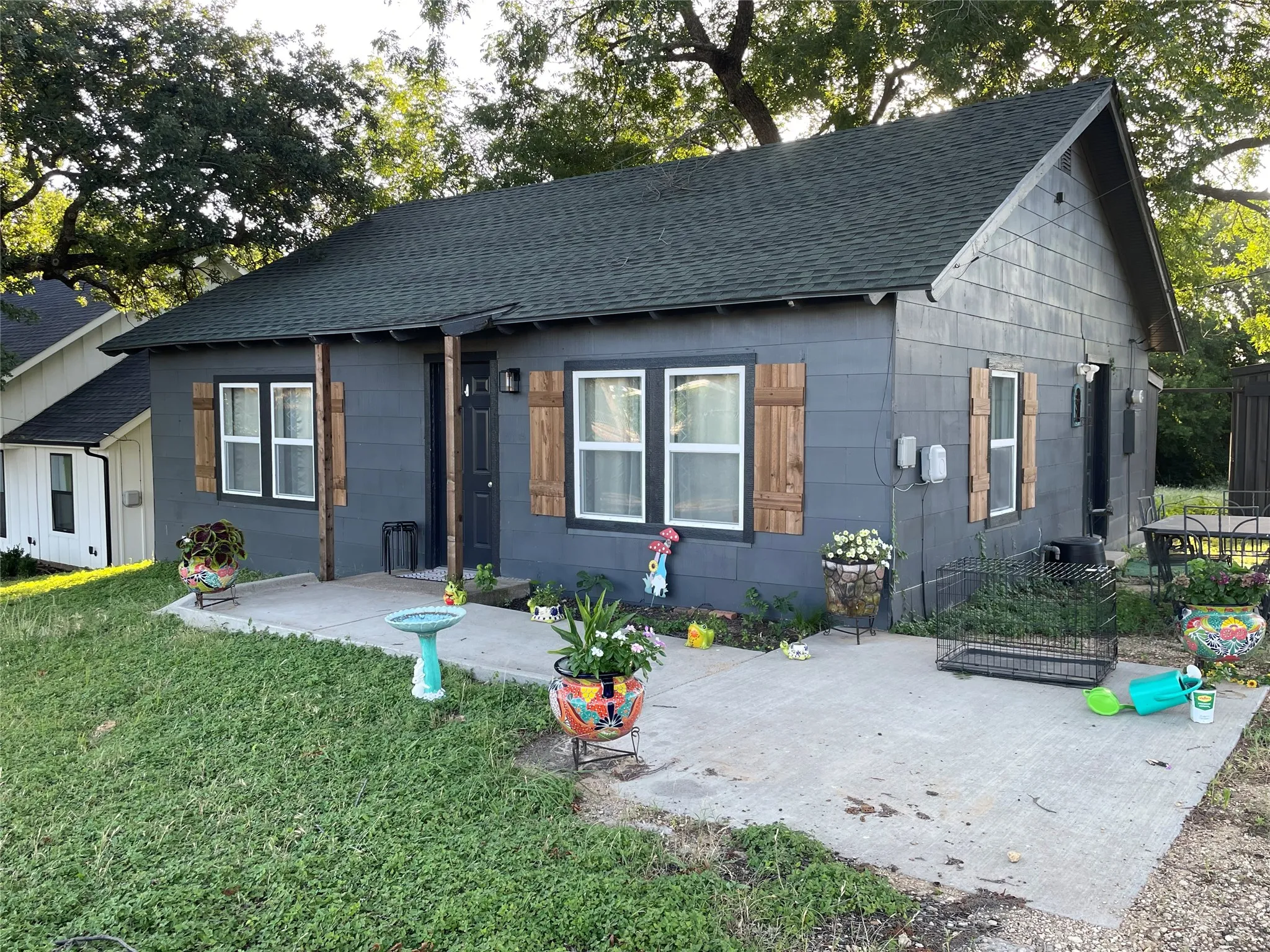 Charcoal gray siding exterior with white window frames and natural wood shutters