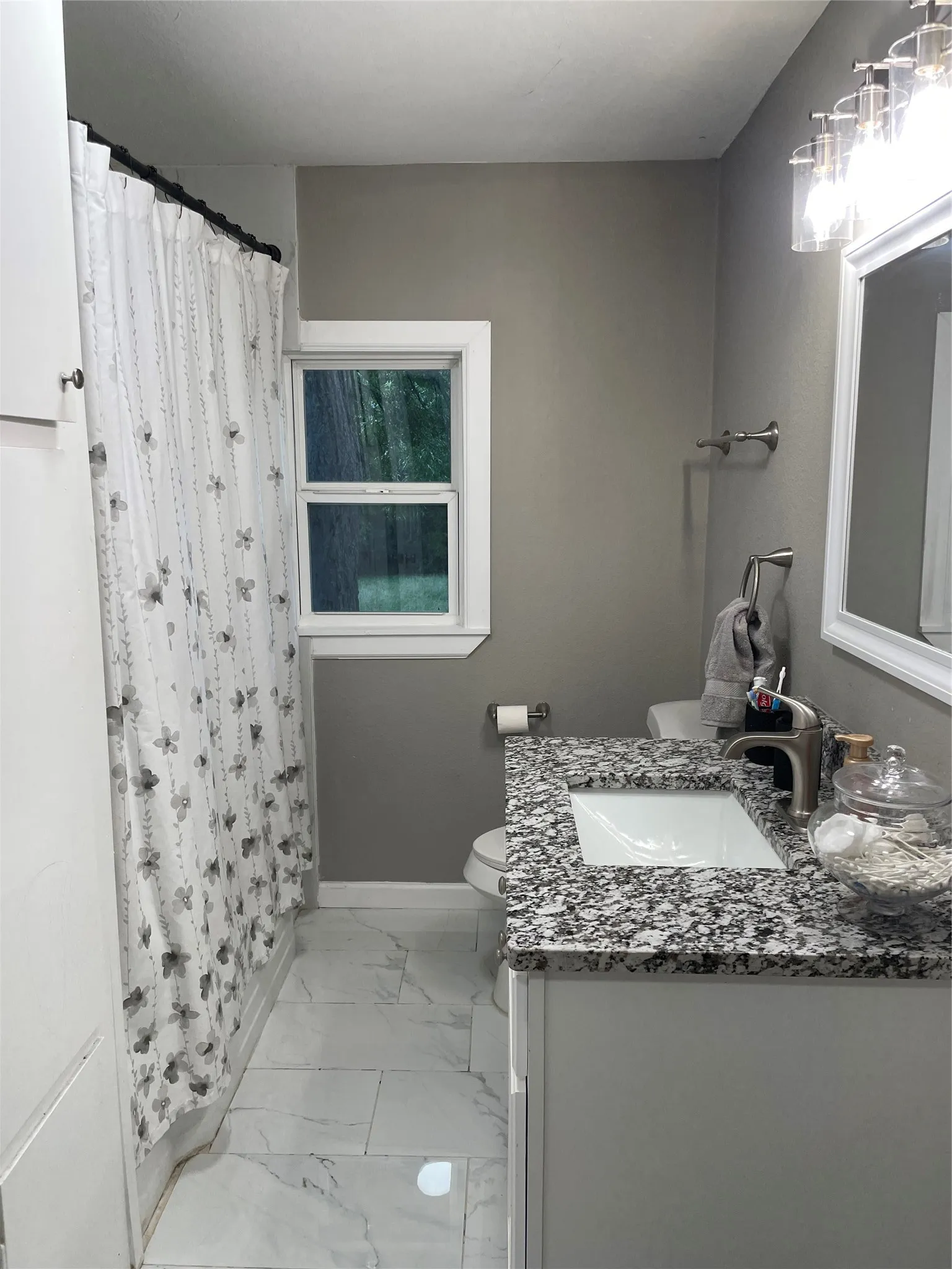 Bathroom with a white vanity featuring a speckled countertop and an integrated sink