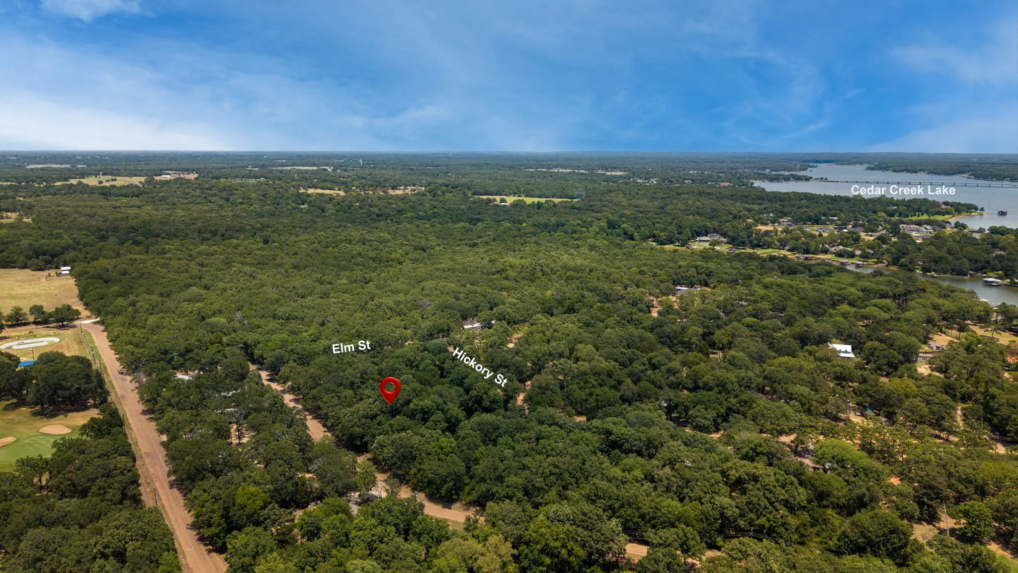 Expansive wooded acreage featuring Cedar Creek Lake in the background