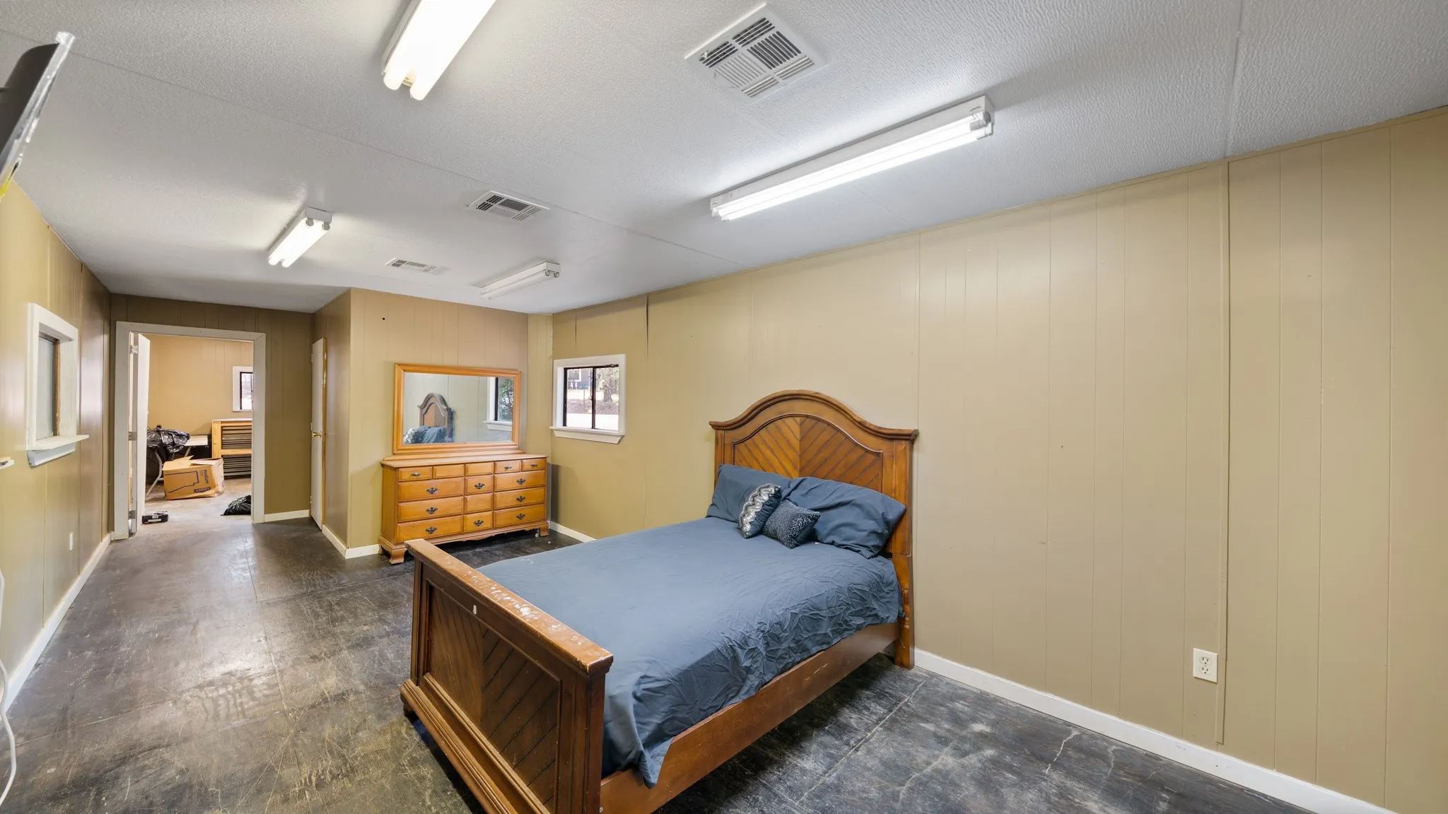 Room featuring panel walls, multiple windows with white trim, and a hard surface floor