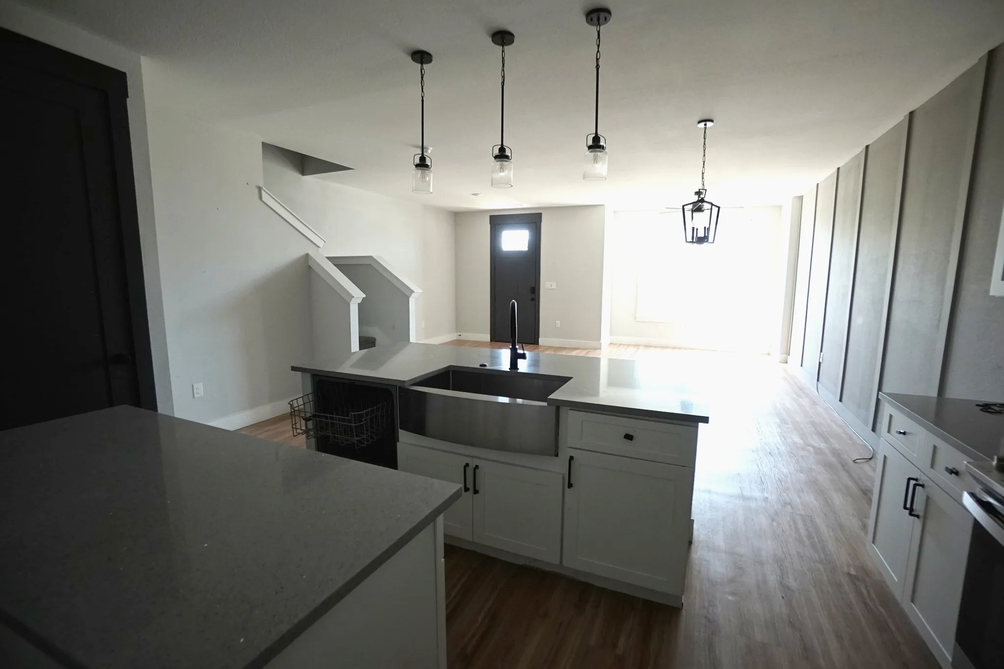 Kitchen island with quartz countertops, undermount sink, and pendant lighting