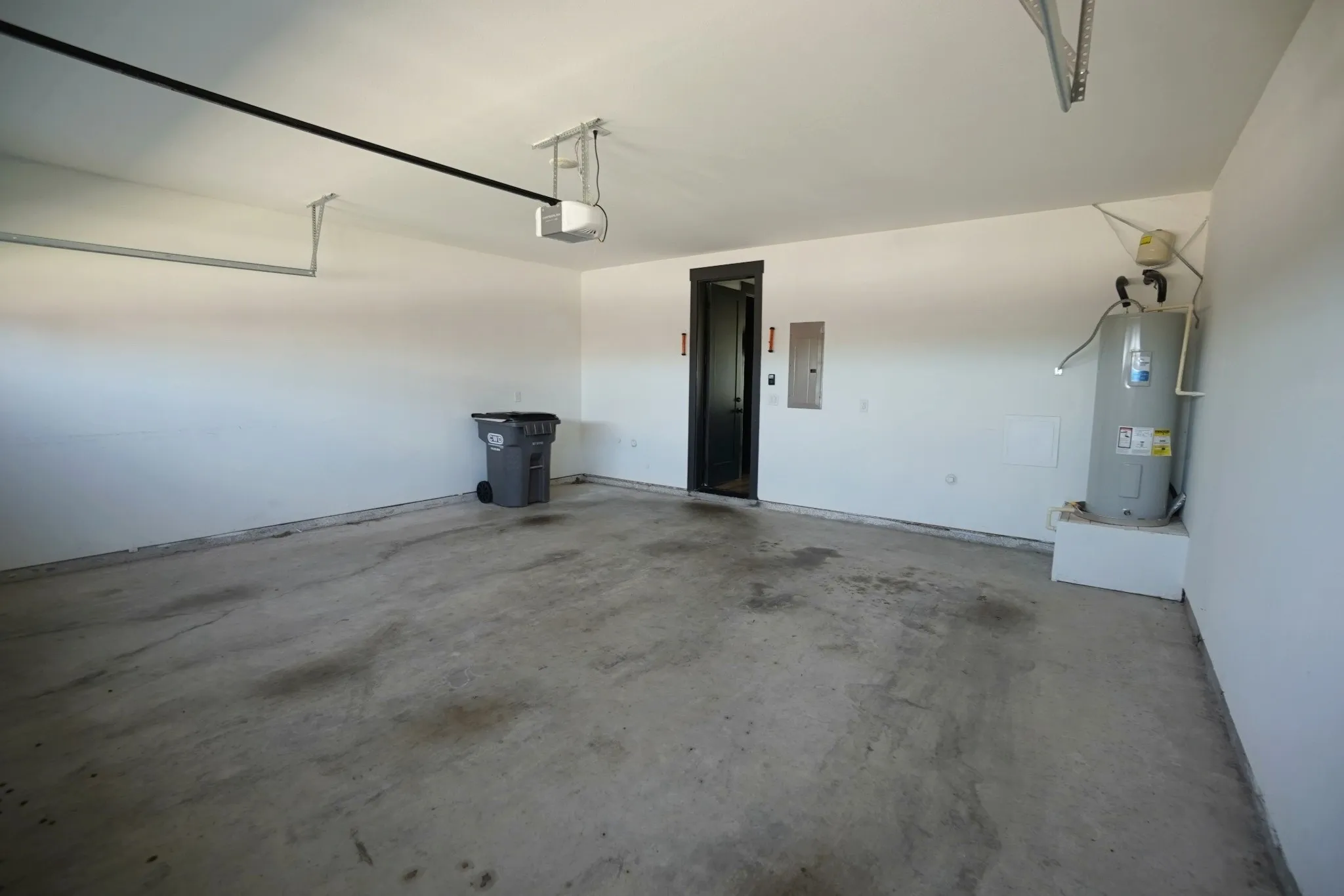 Enclosed garage with a concrete floor, painted walls, and an interior access door