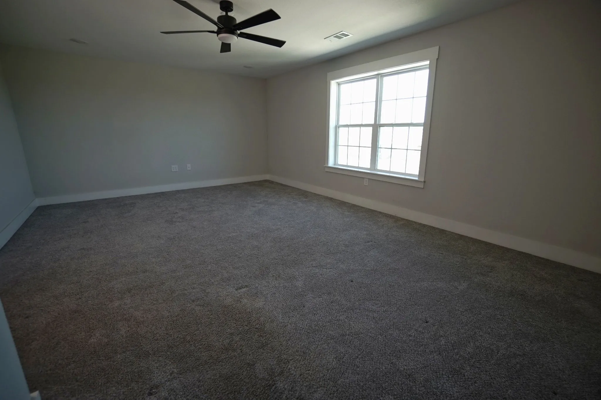 Recessed lighting, ceiling fan, neutral wall paint, white trim, and a window with muntins