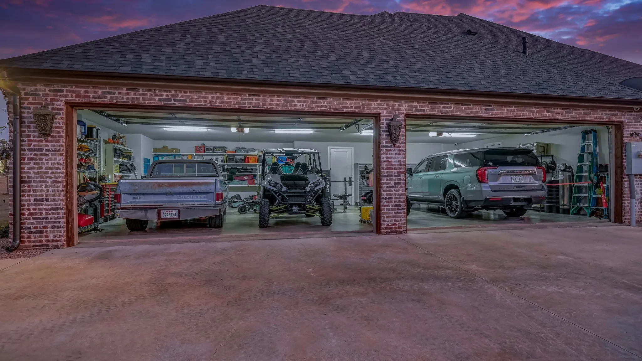 Three-car garage with brick veneer exterior and shingle roofing