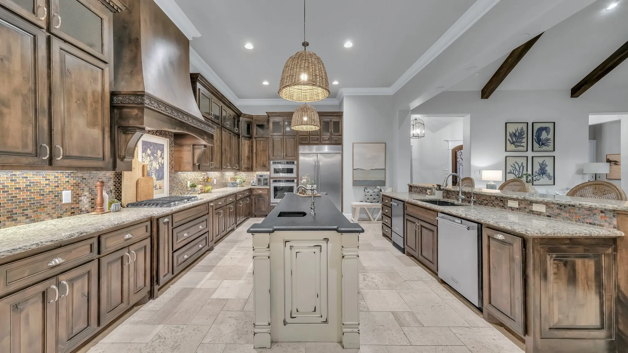 Gourmet kitchen featuring extensive custom wood cabinetry, granite countertops, a mosaic tile backsplash, and stainless steel appliances