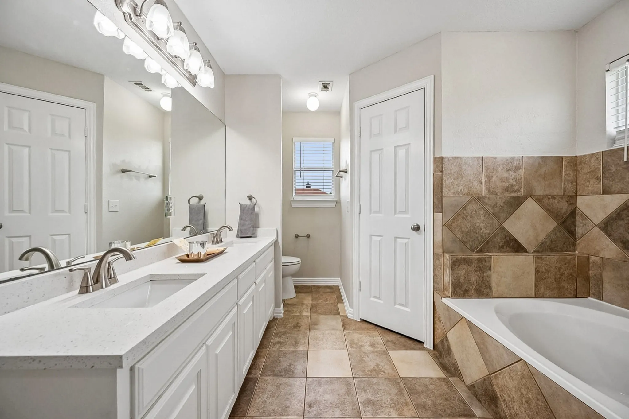 Dual vanity with white cabinetry and light-toned countertops