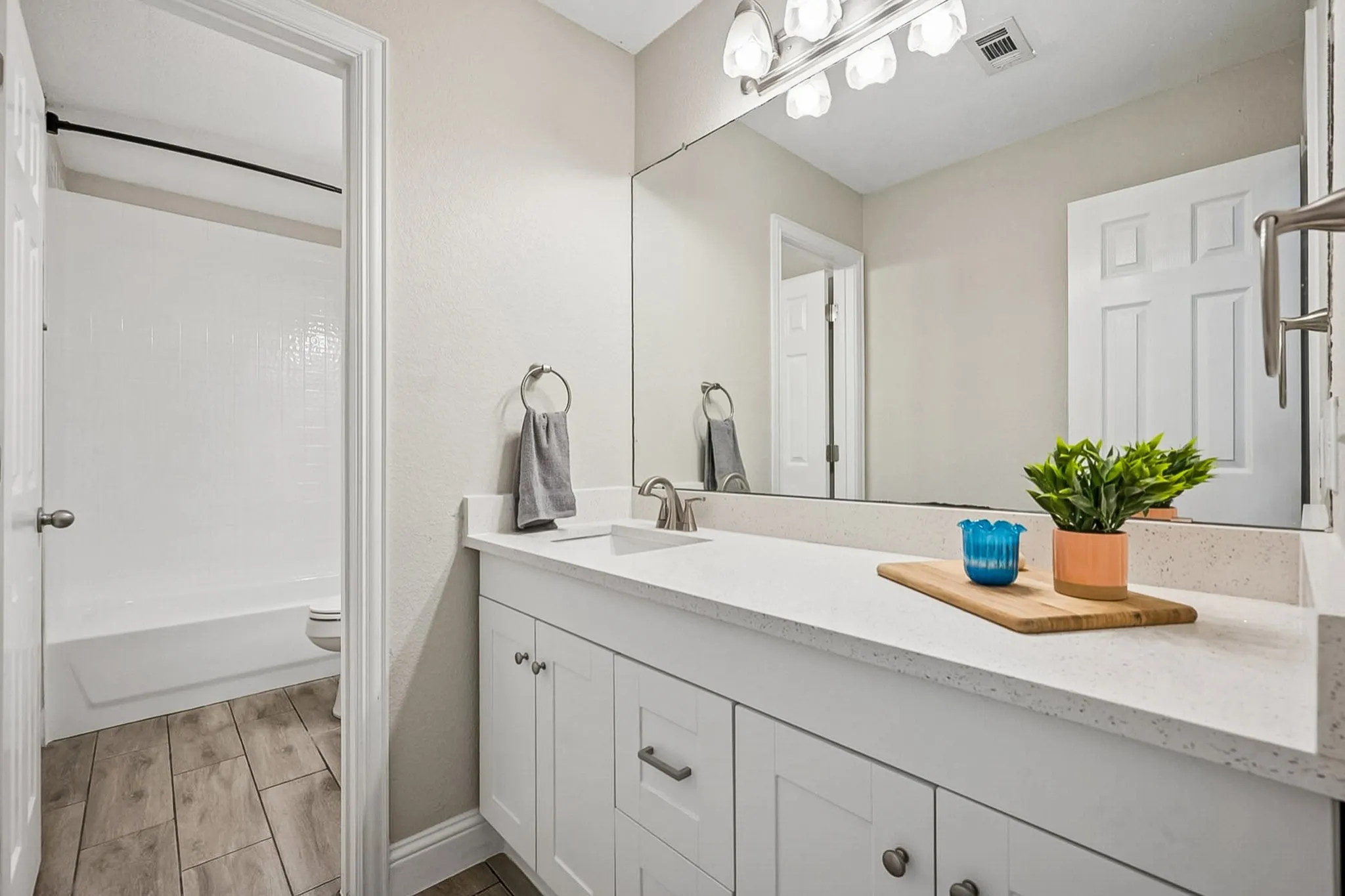 Bathroom featuring a long single vanity with white cabinetry and a light-colored countertop