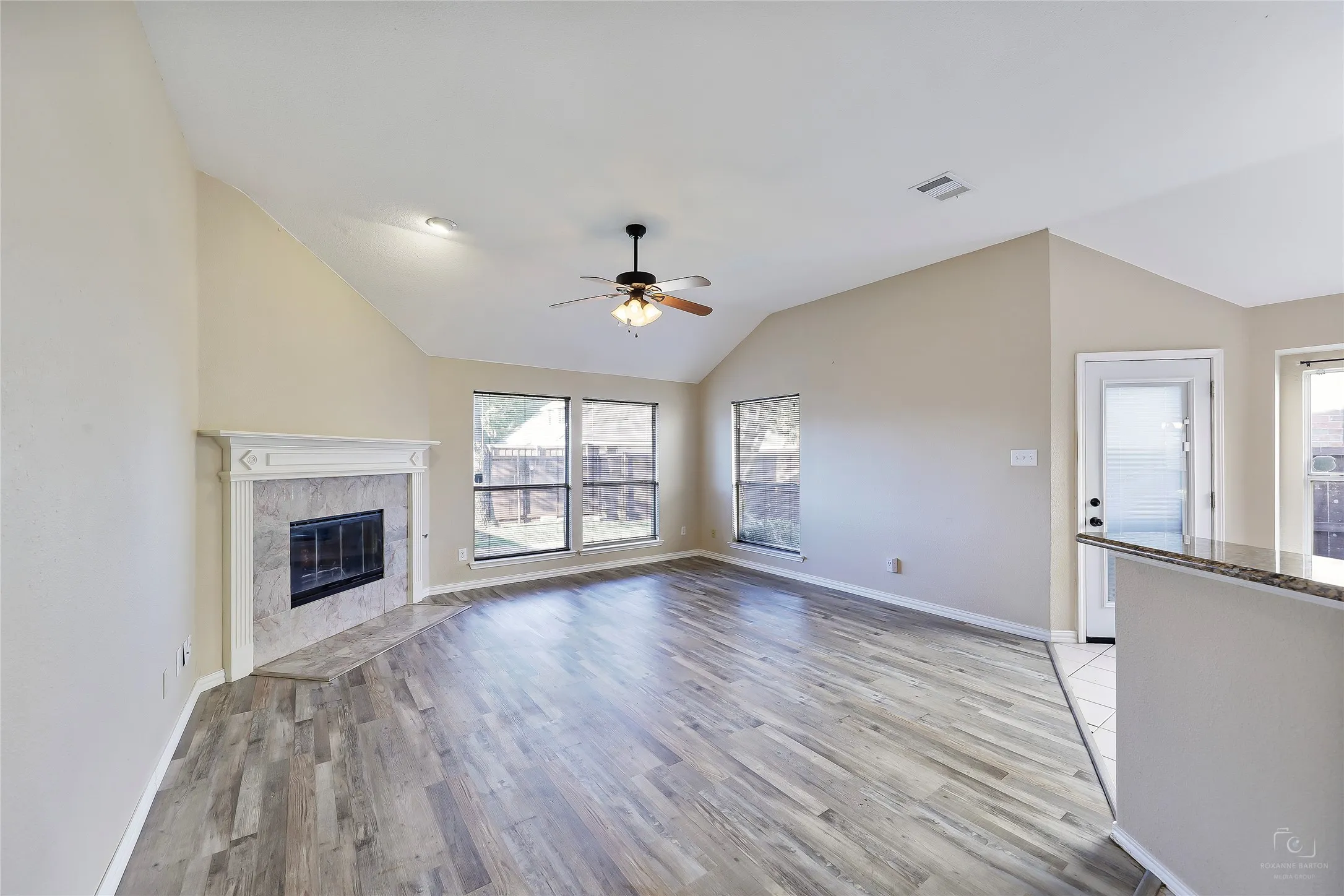 Spacious living area featuring wood-finish flooring and vaulted ceilings
