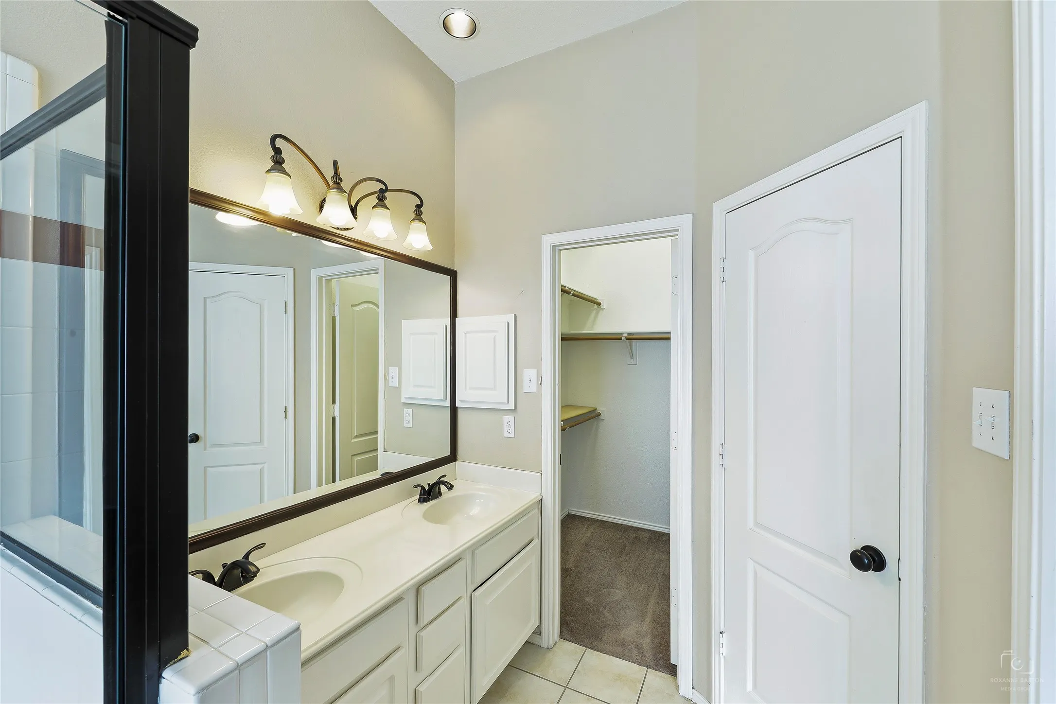 Dual sink vanity with white cabinetry and integrated sinks