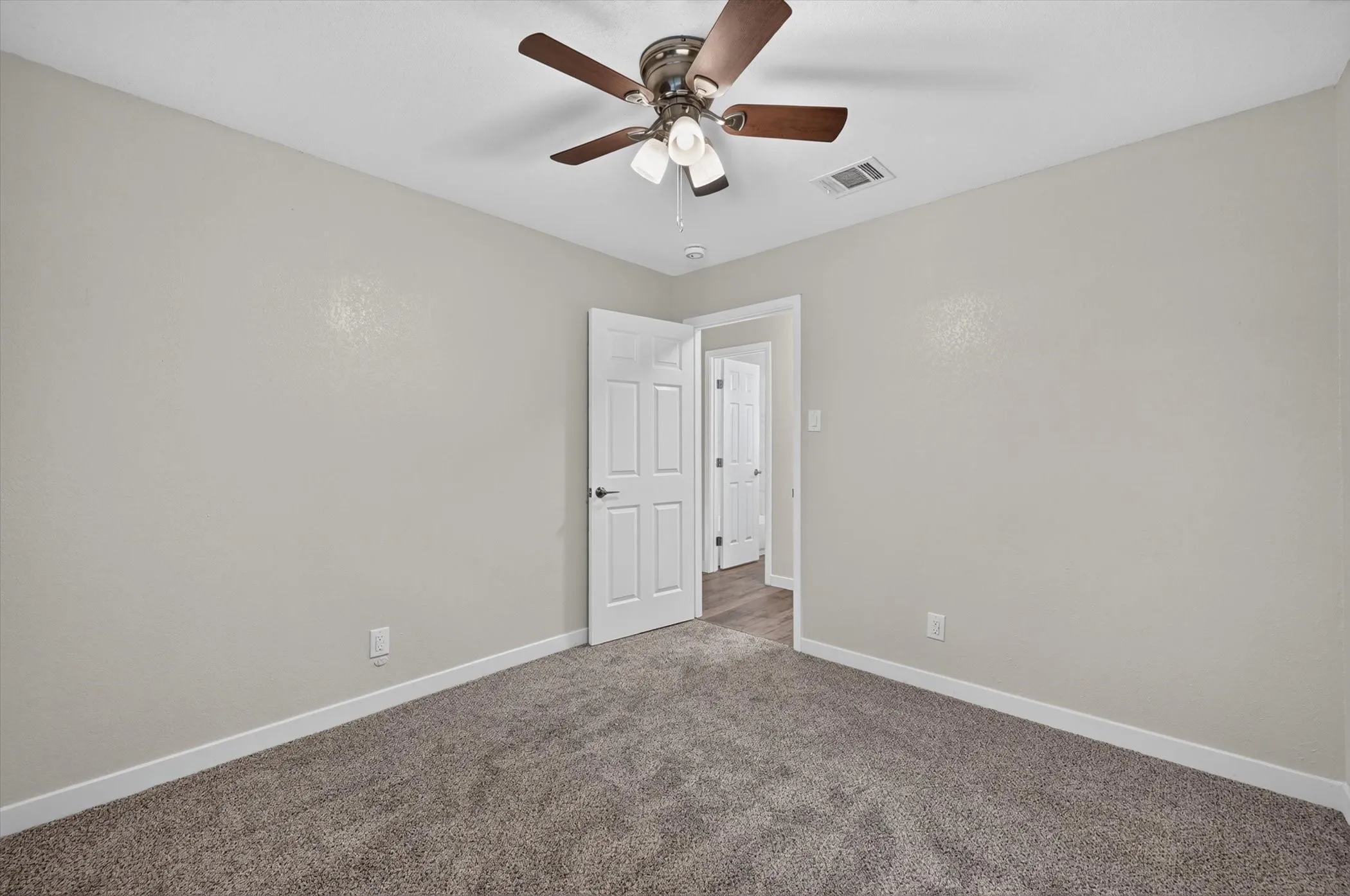 Carpeted room with light neutral wall paint