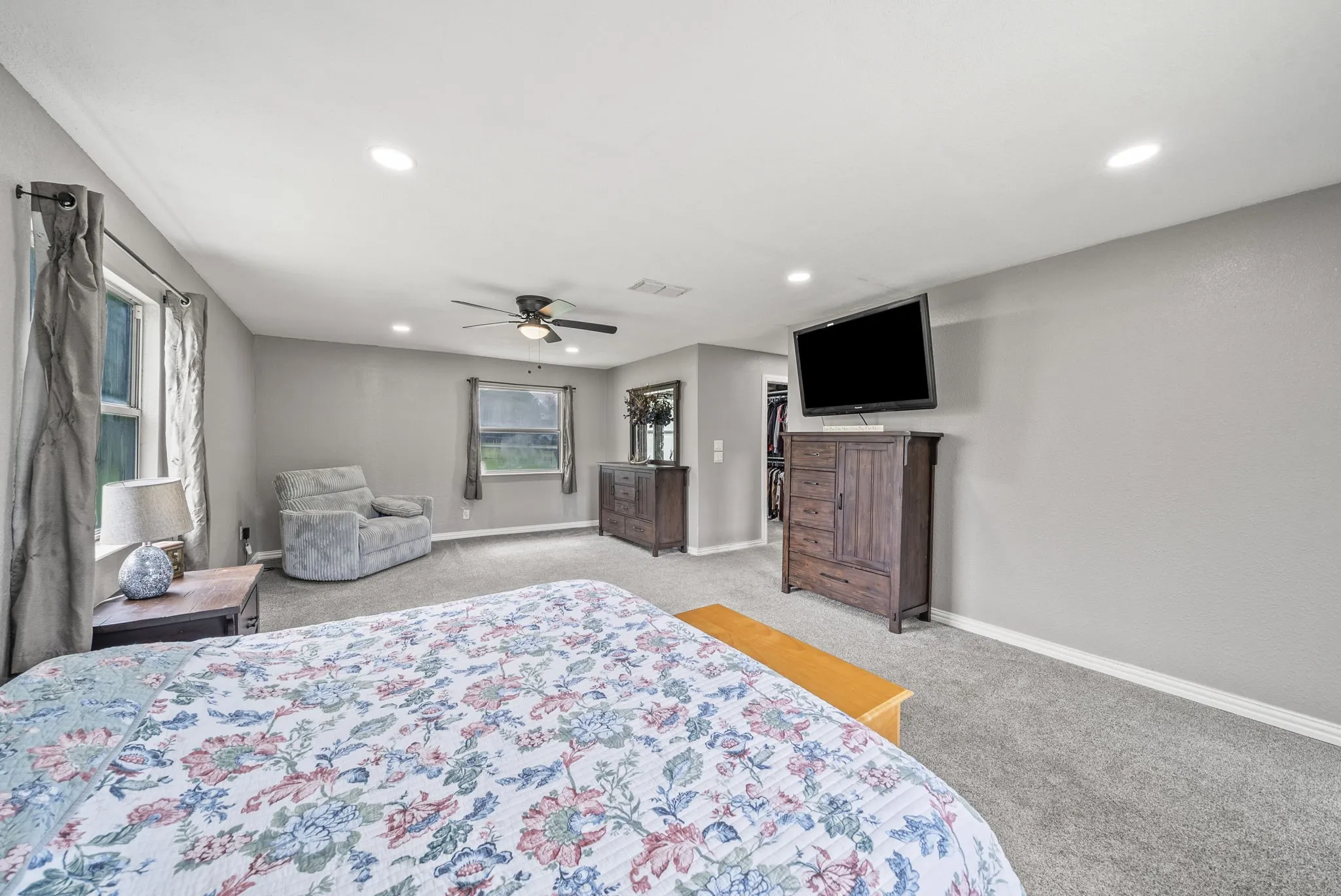 Spacious room featuring neutral carpeting, a ceiling fan with integrated lighting, and recessed ceiling lights