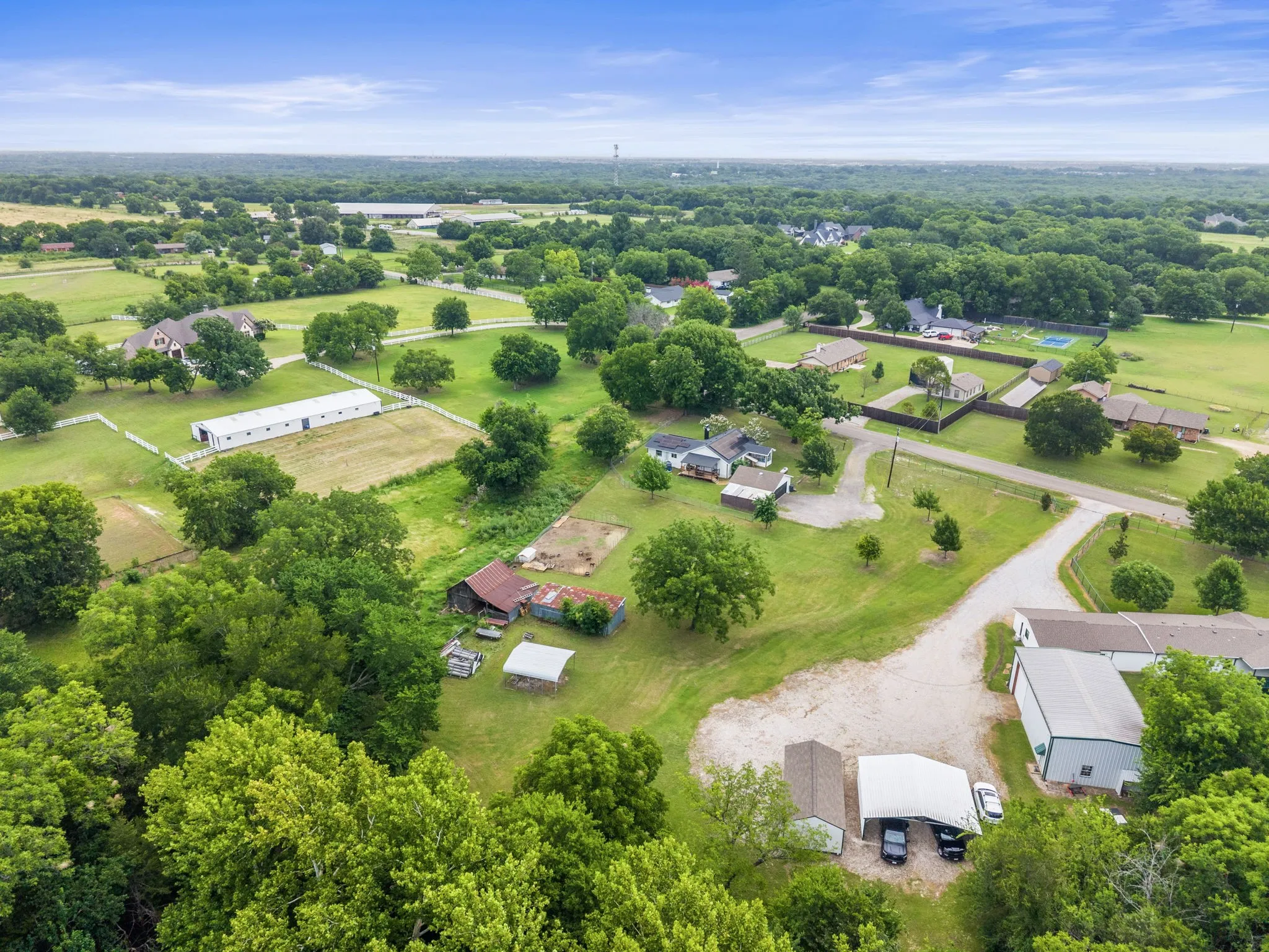 Expansive aerial landscape featuring a residential property amidst abundant mature trees