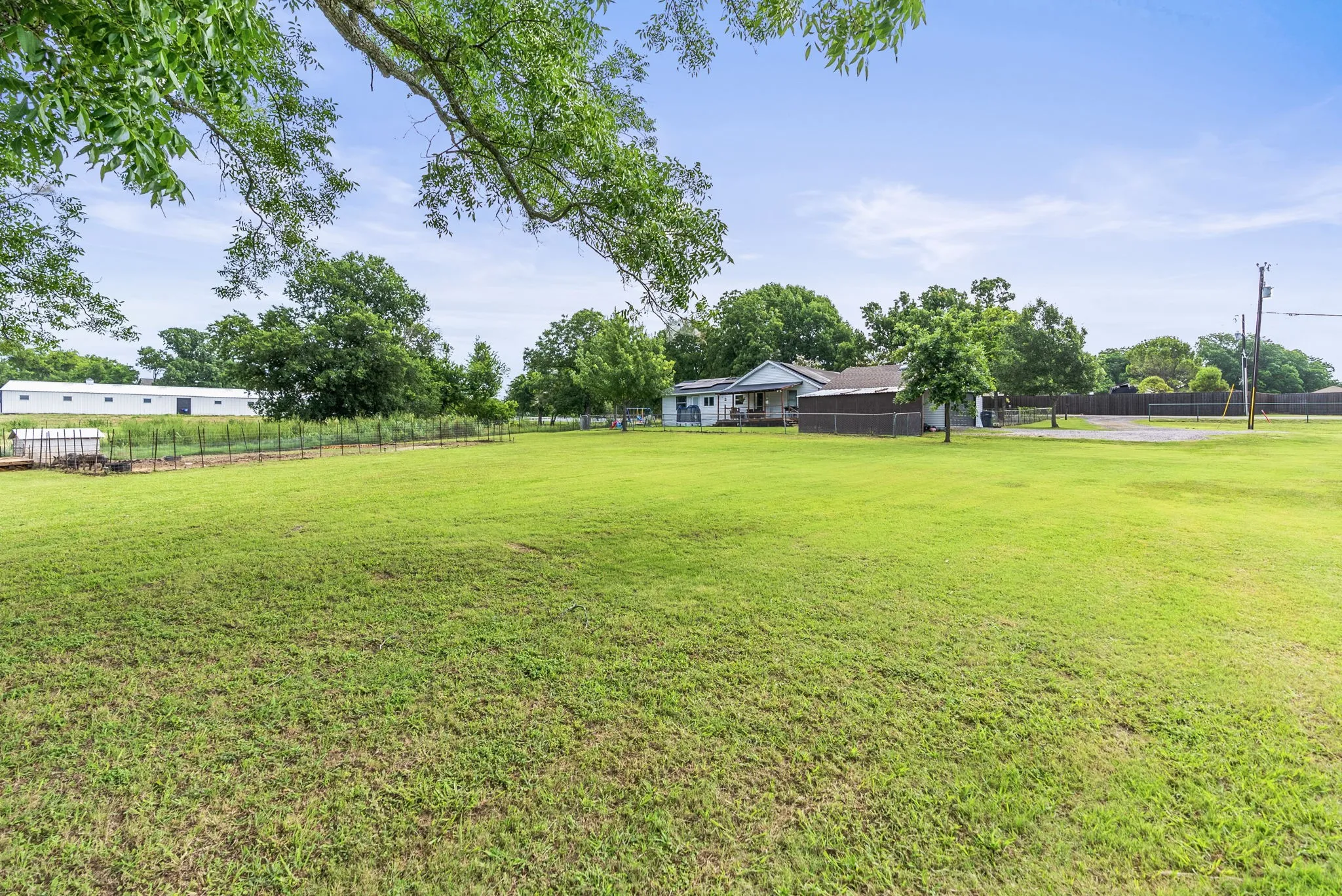 Expansive grassy area with mature perimeter trees