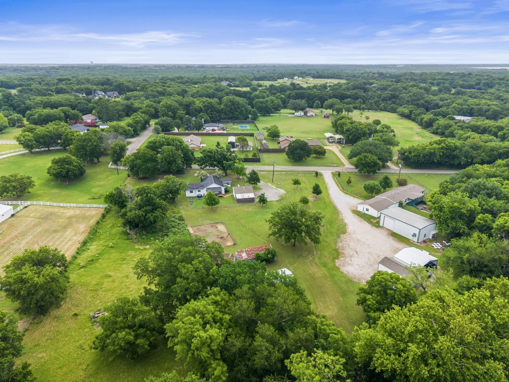 Expansive aerial panorama showcasing a verdant landscape with scattered residential properties