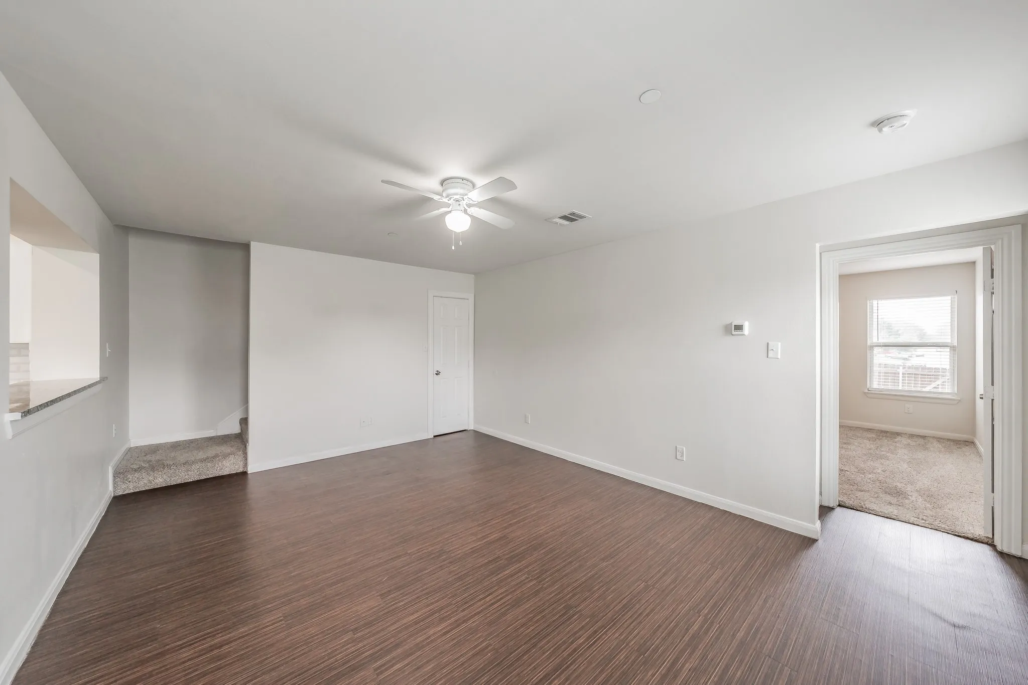 Stairway to second level, closed door is storage under stairway. Open door leads to Master bedroom
