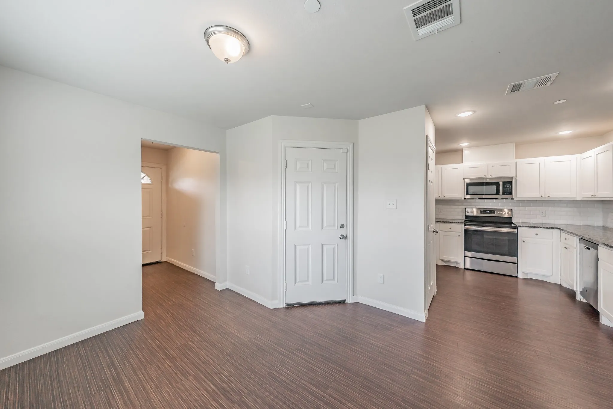 Dinning area with open concept kitchen. Door leads to garage