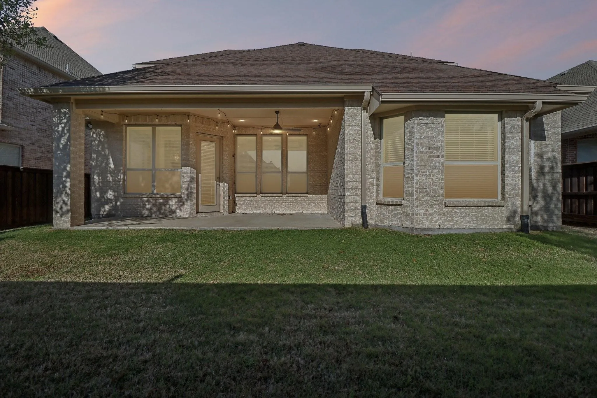 Covered patio with string lighting, ceiling fan, and direct access to interior spaces