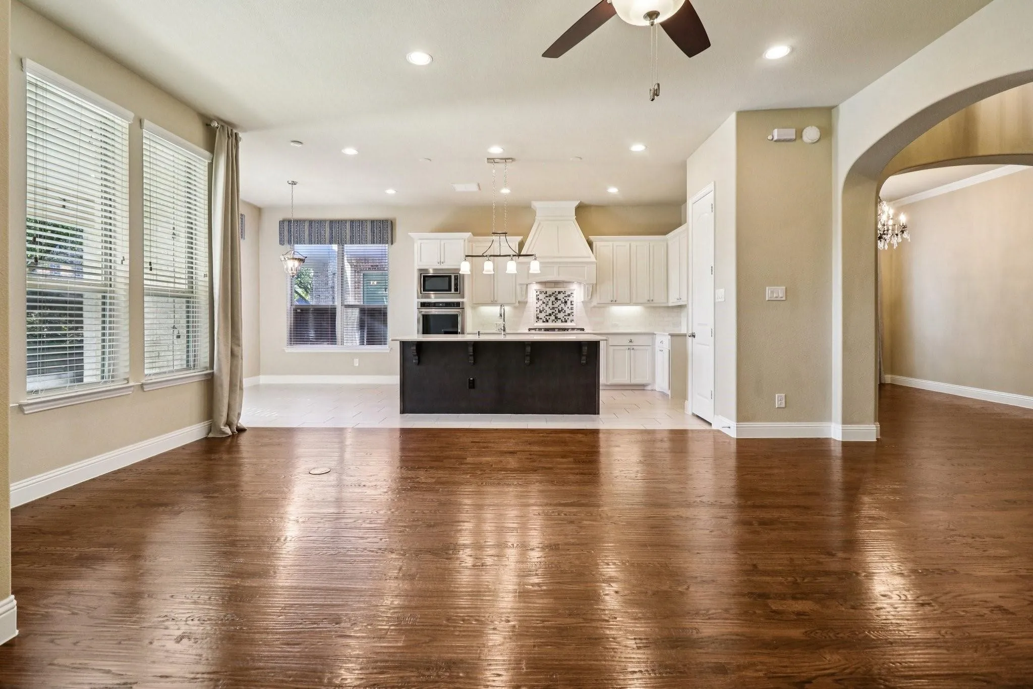 Expansive main living area featuring wood-finish flooring, recessed lighting, and a ceiling fan