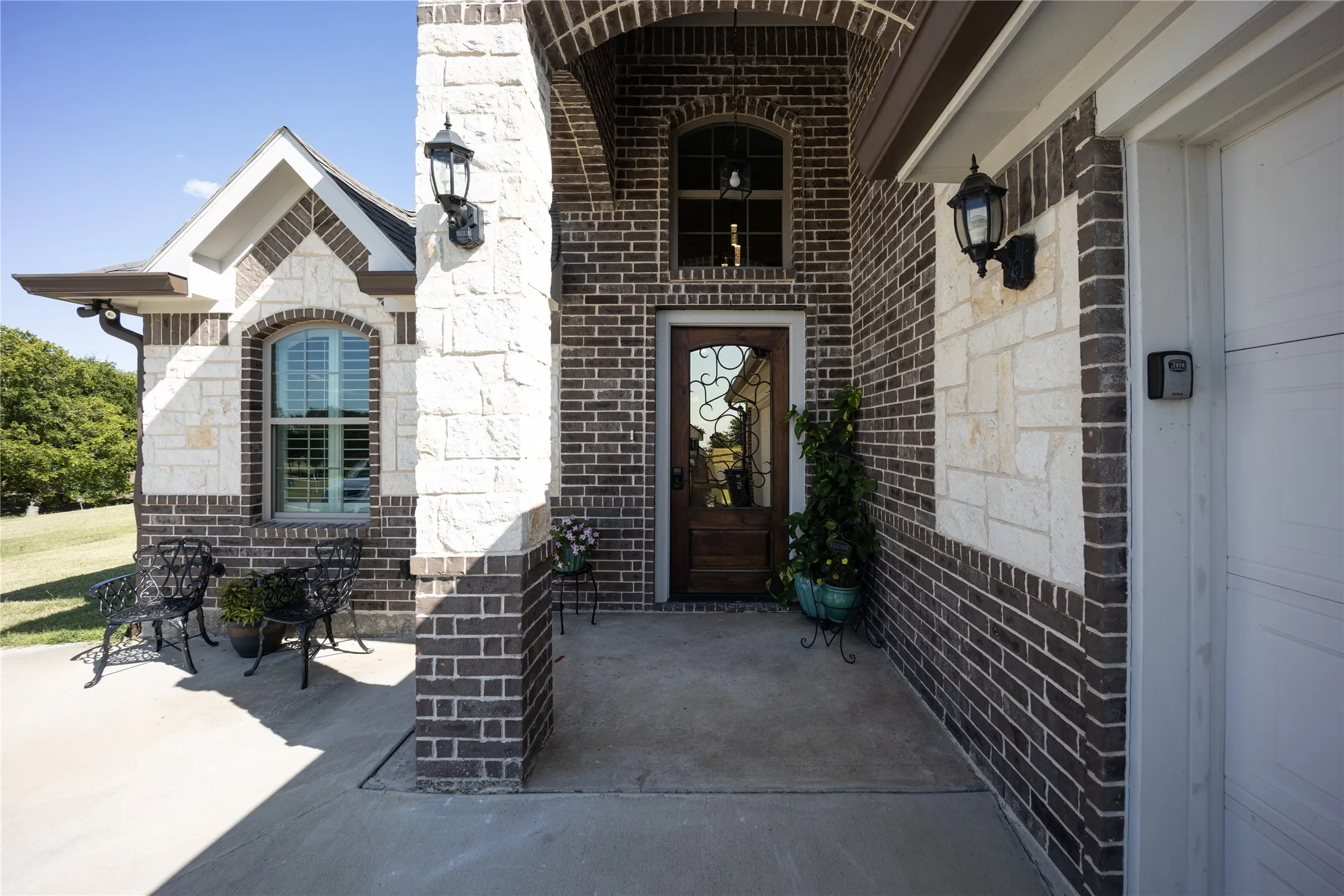 Brick and stone veneer exterior featuring an arched entryway