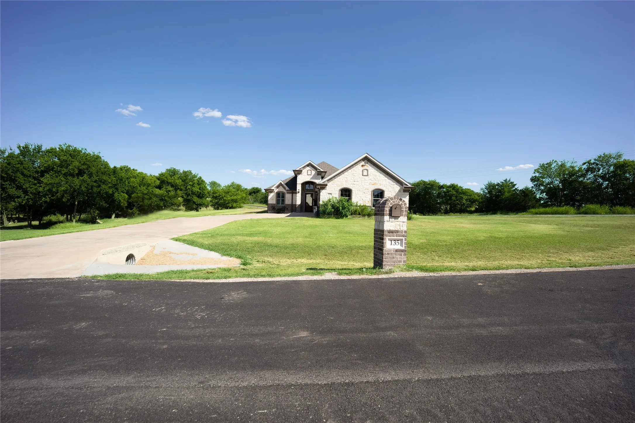 Traditional-style home featuring a light-colored brick exterior and dark trim accents