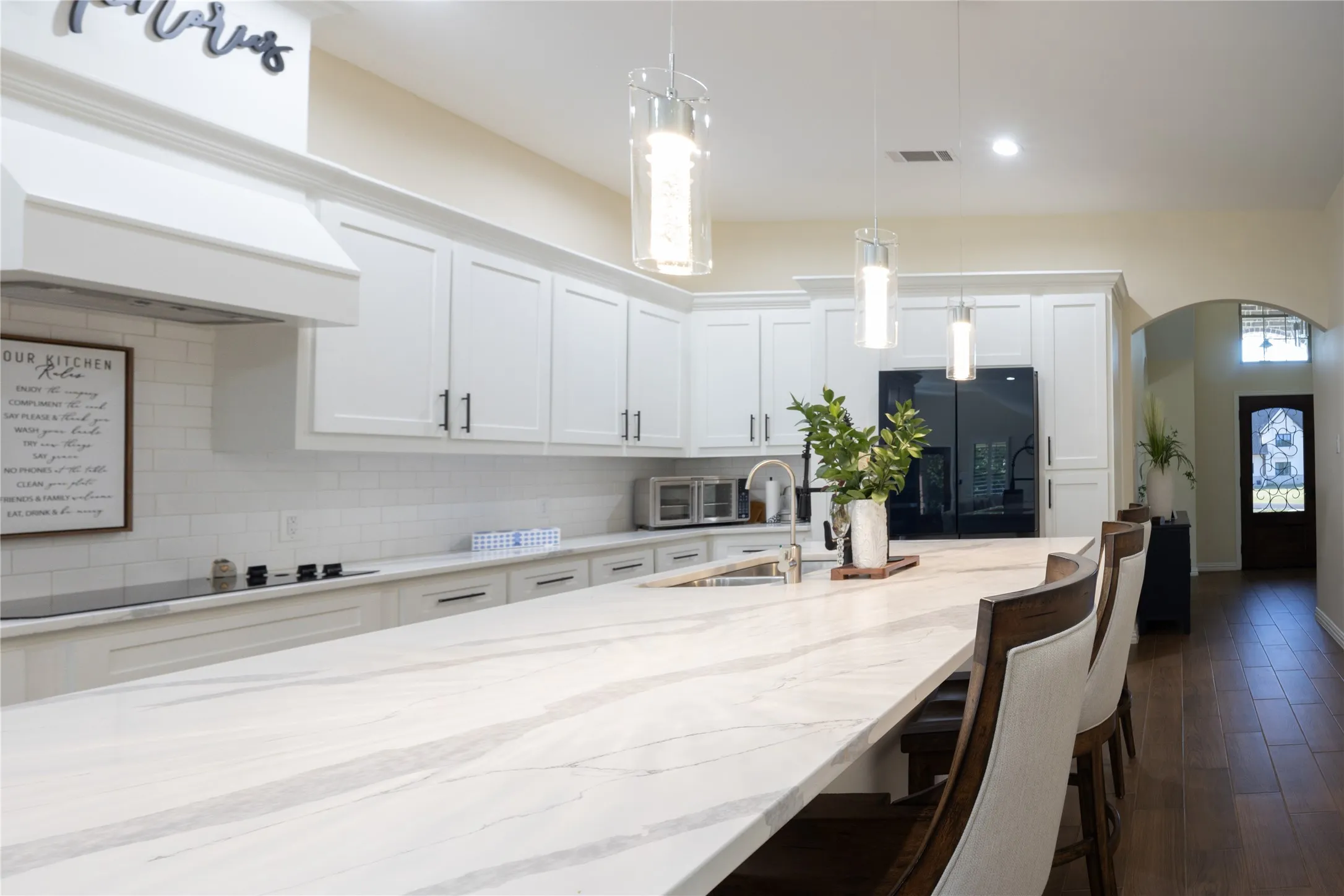 Expansive kitchen island featuring a light-toned countertop with natural veining